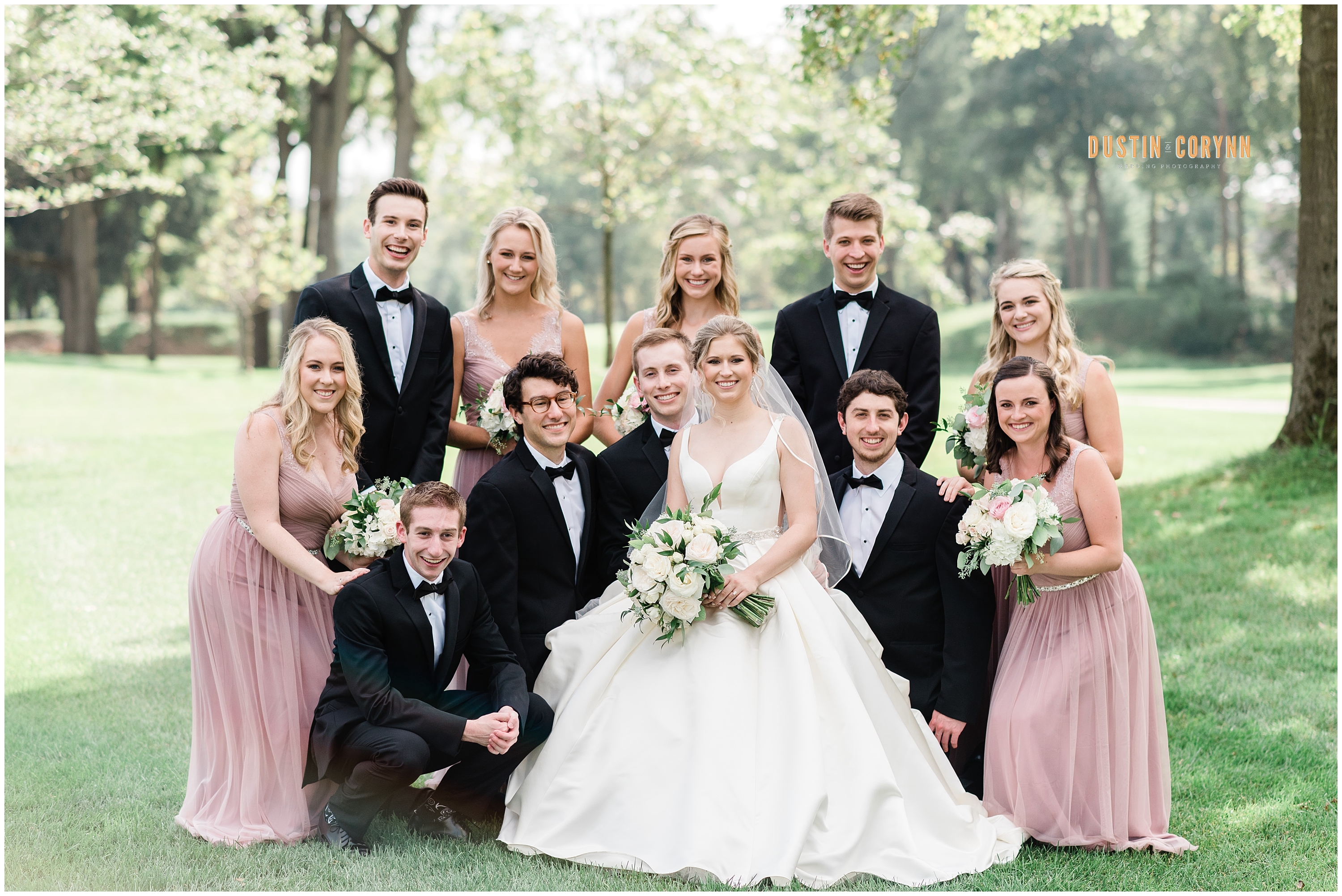 Fort Wayne wedding photographer captures bride and groom with wedding party wearing pink dresses and tuxedos