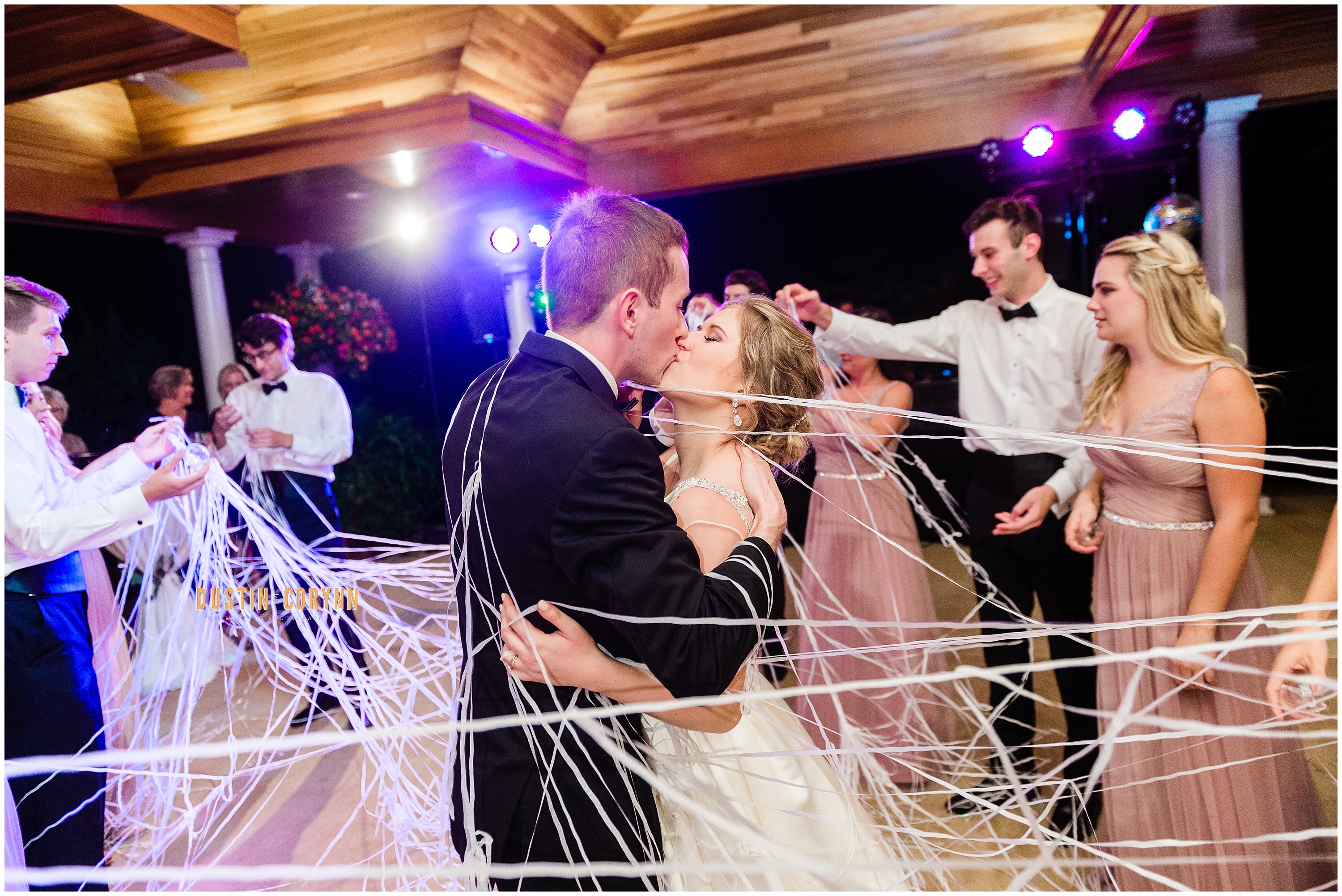 Fort Wayne wedding photographer captures couple kissing through streamers 
