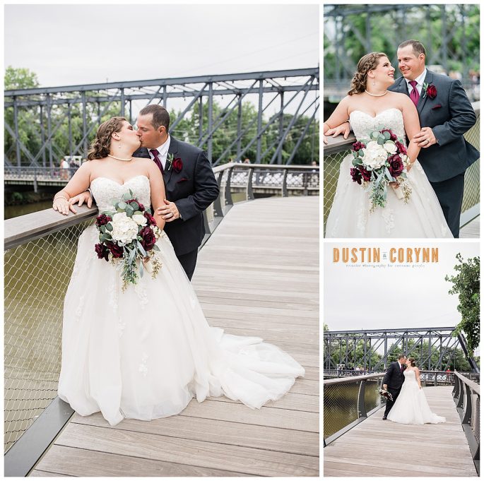 Fort Wayne wedding photographers capture bride and groom kissing on bridge after wedding ceremony