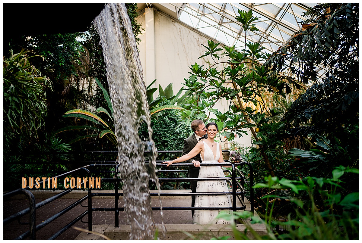 bride and groom holding each other in a greenhouse for their Fort Wayne wedding 