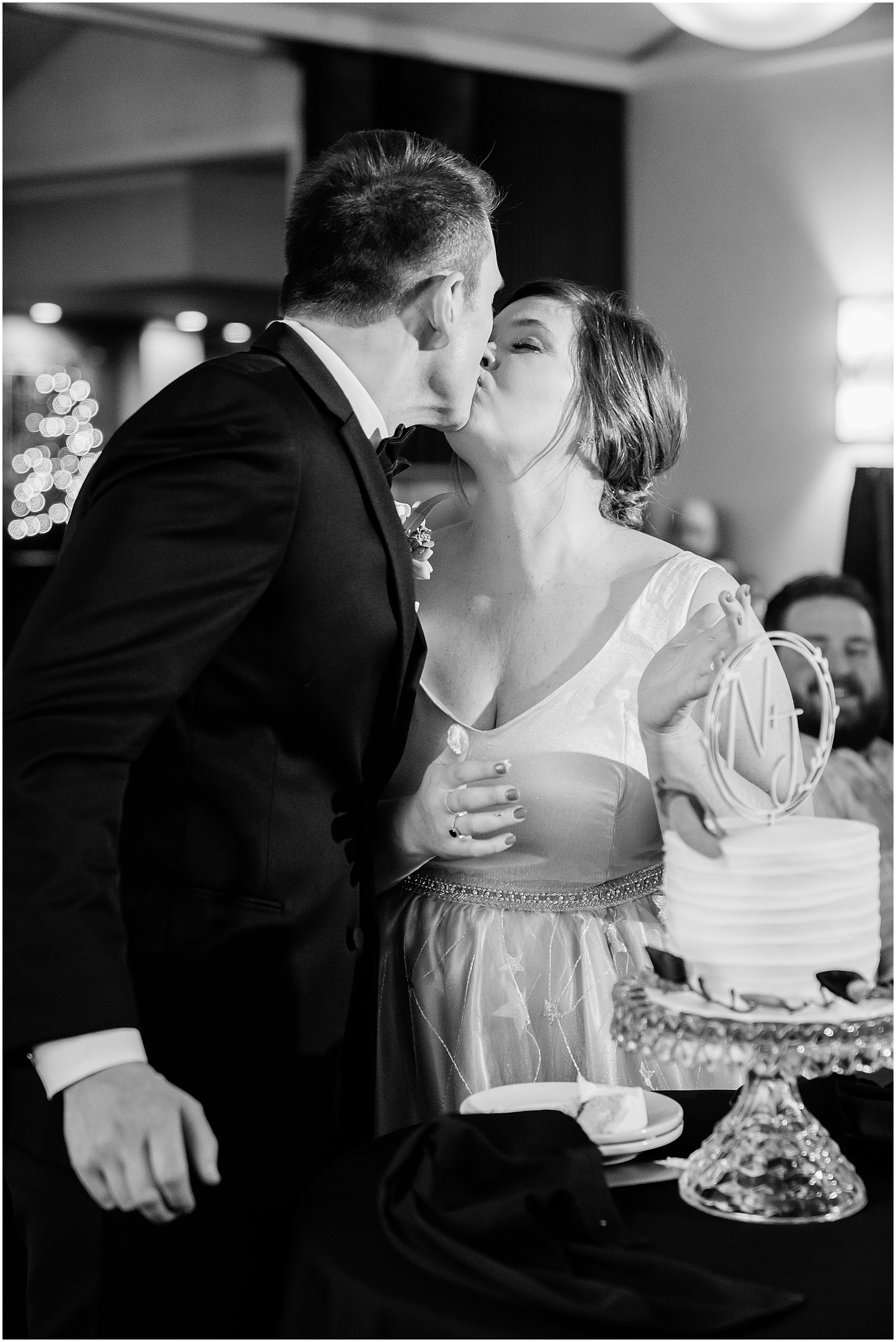 bride and groom kissing after cake cutting