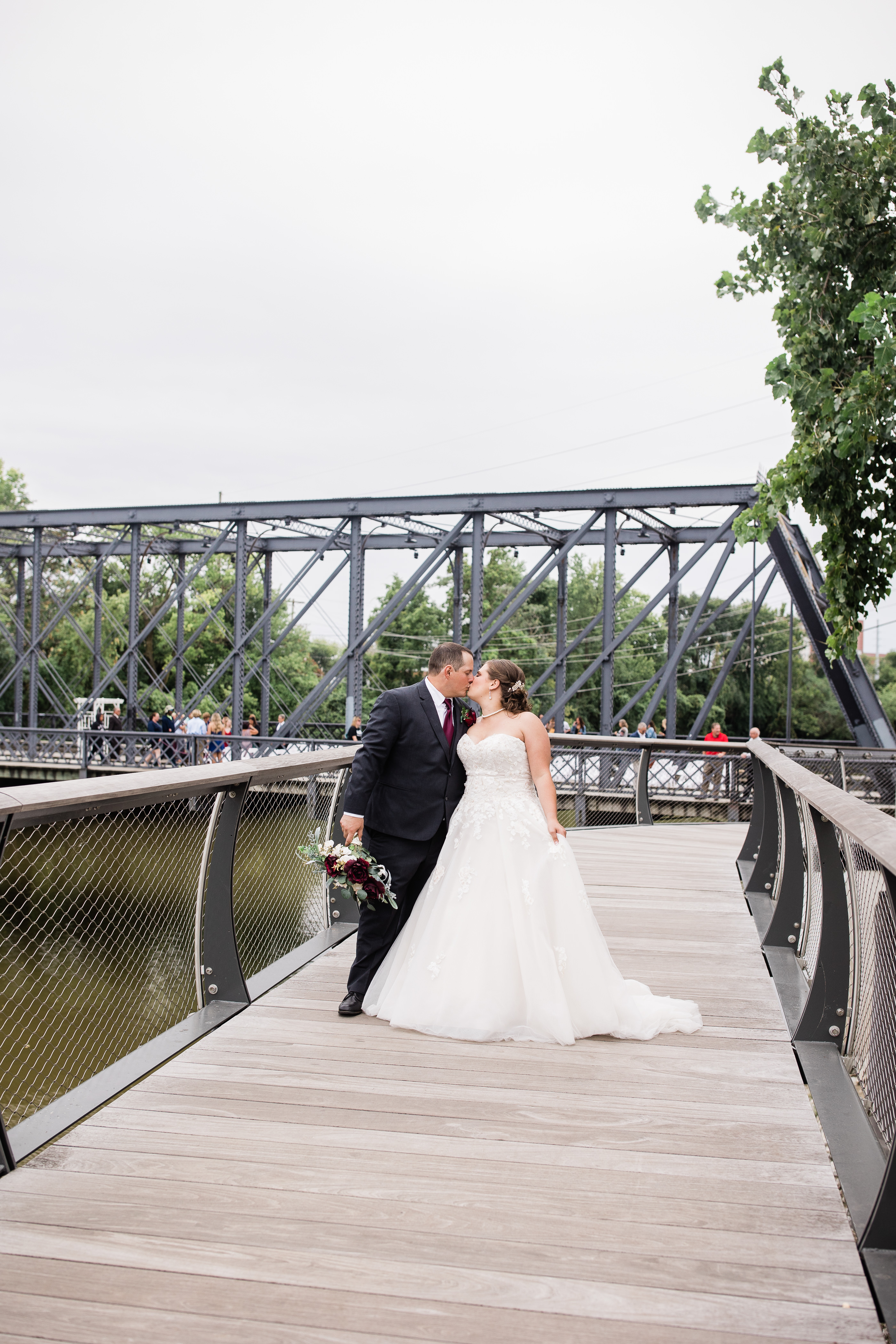 newly married couple kissing by historic wells bridge