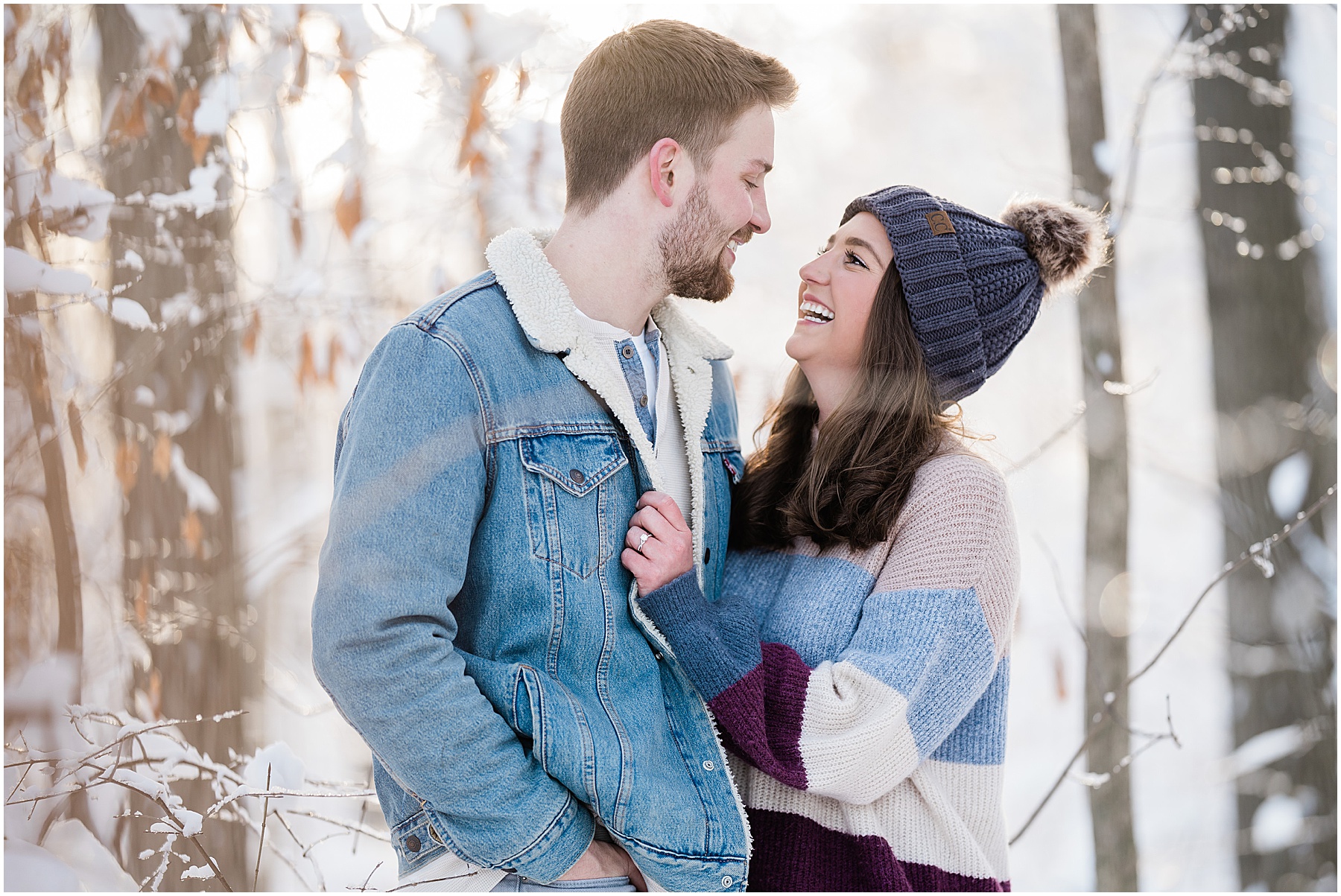 man and woman smiling at one another during winter fort wayne engagement session