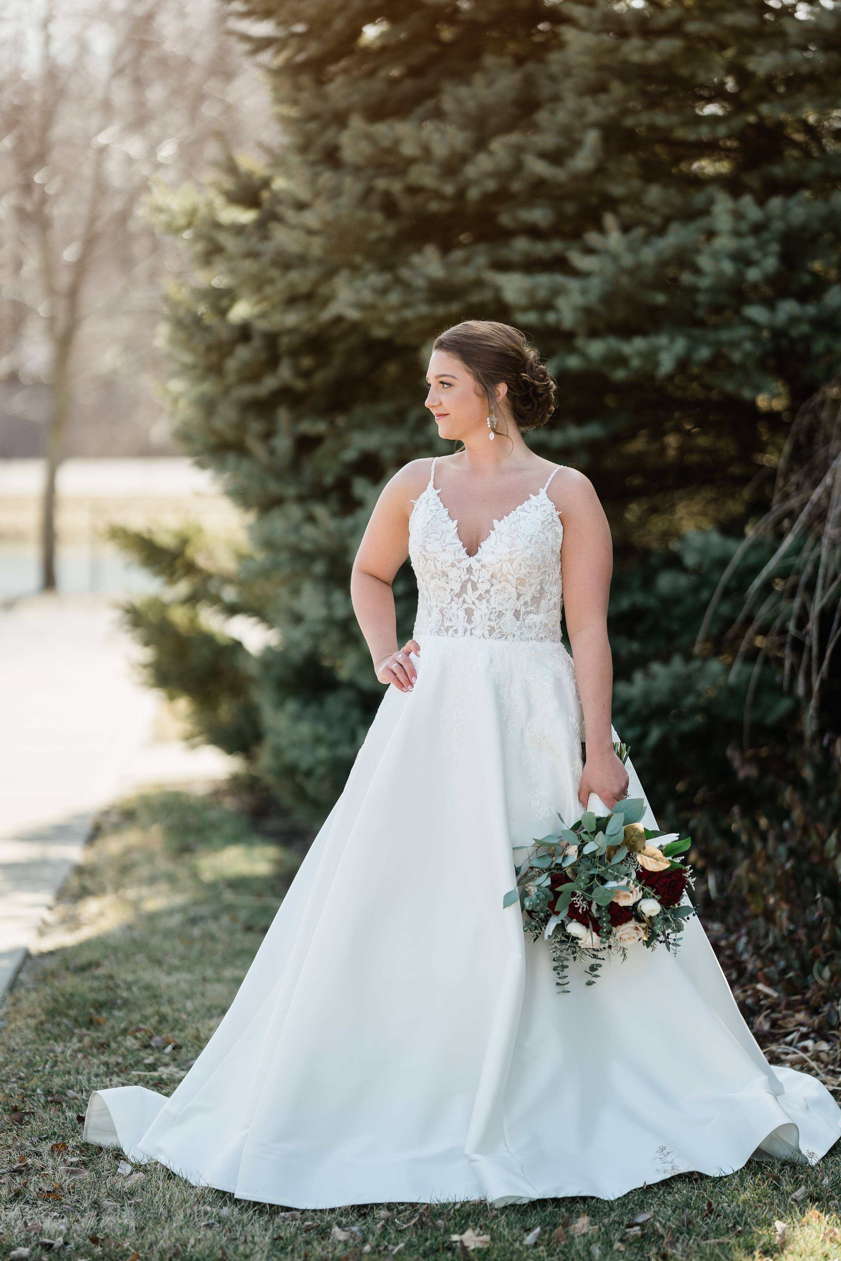 bridal portraits with young bride standing with her hand on her hip as she looks off into the distance