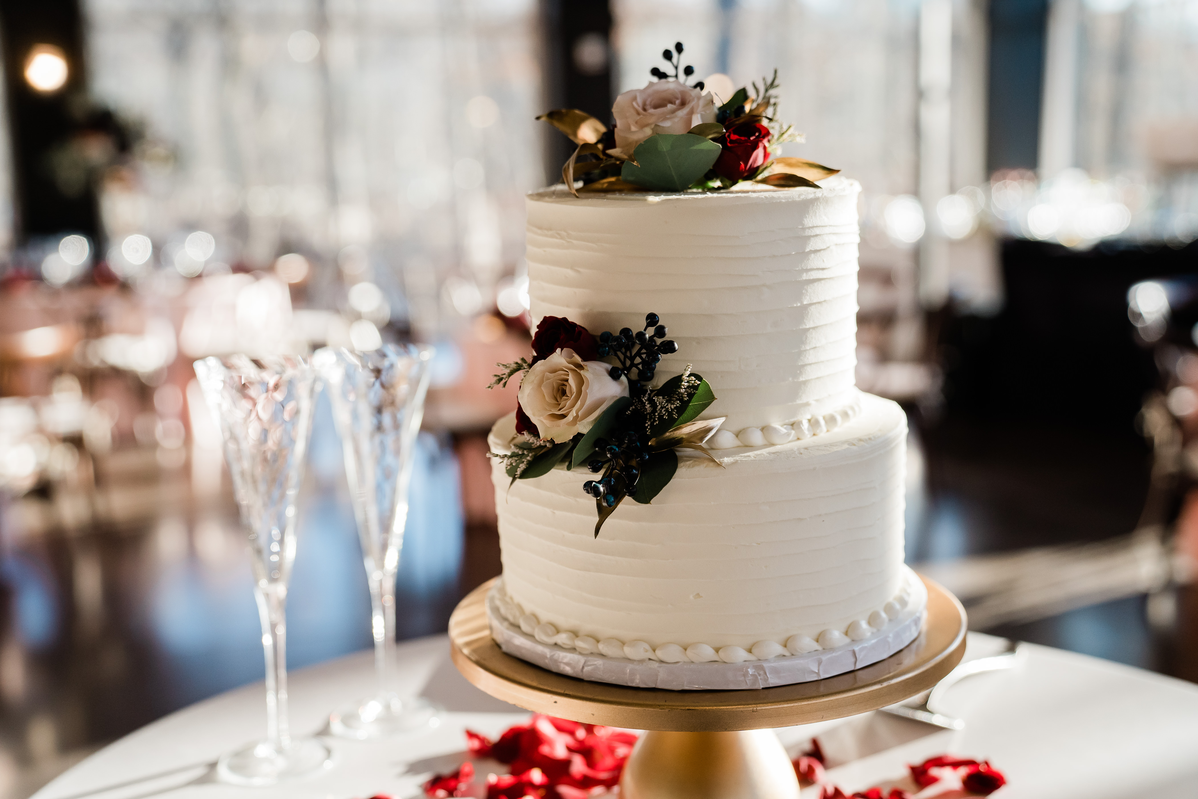 two tier wedding cake with white buttercream and floral details 