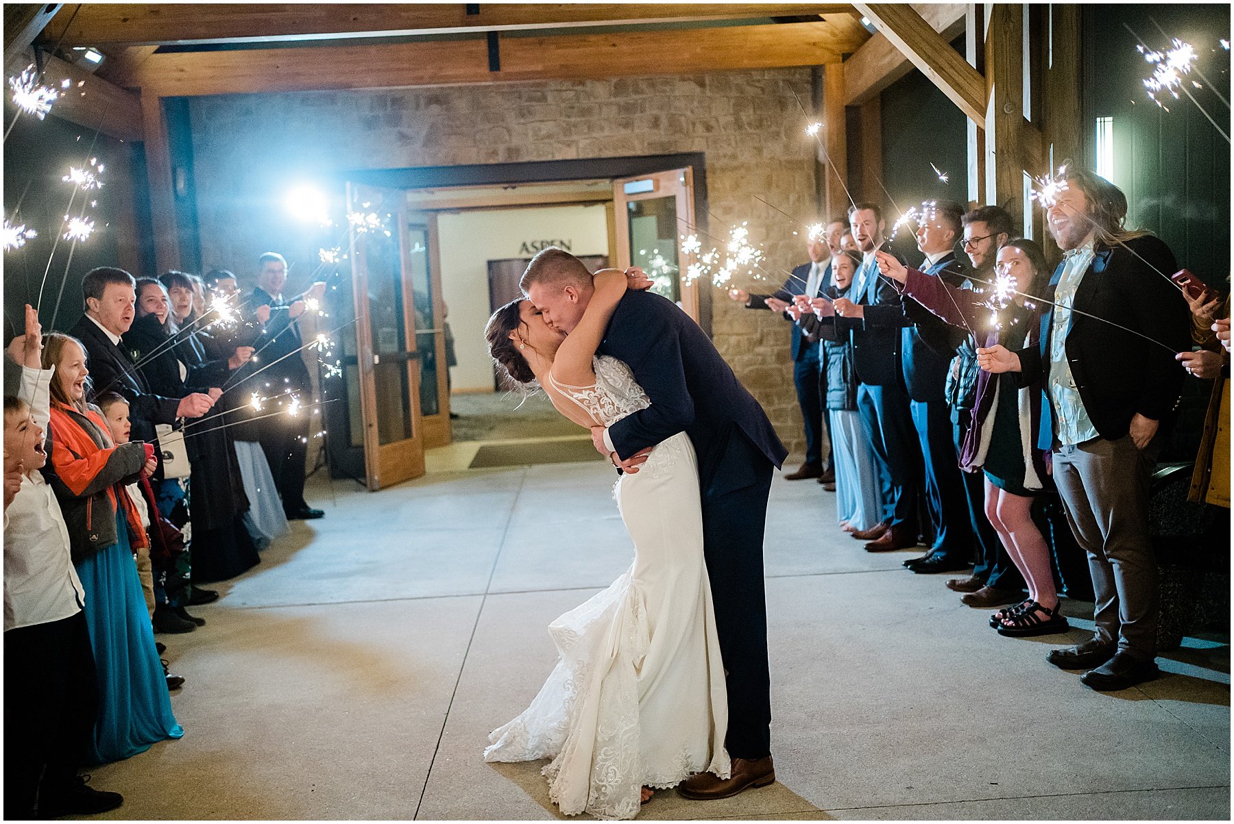 bride and groom kissing during sparkler send off