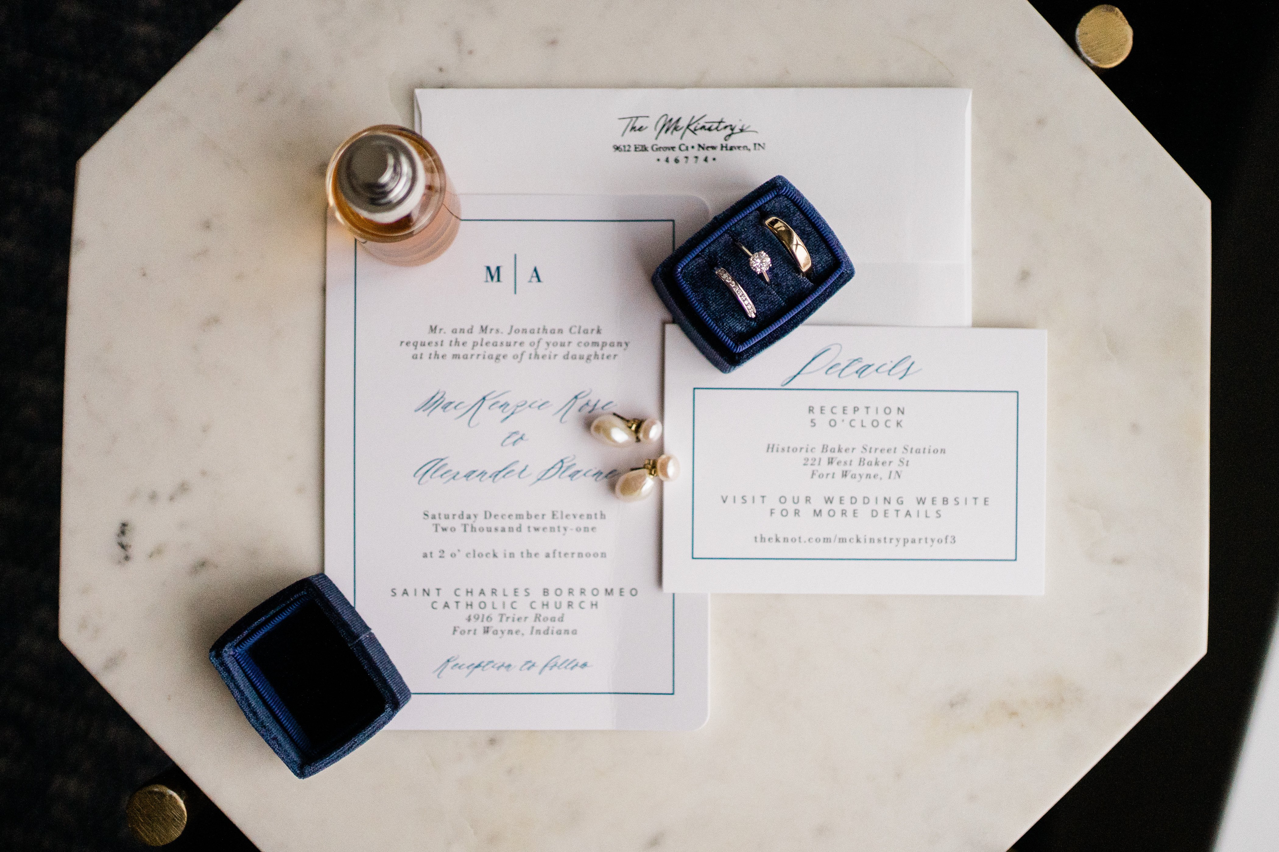 wedding invitation and wedding rings on top of a marble table for a Fort Wayne wedding