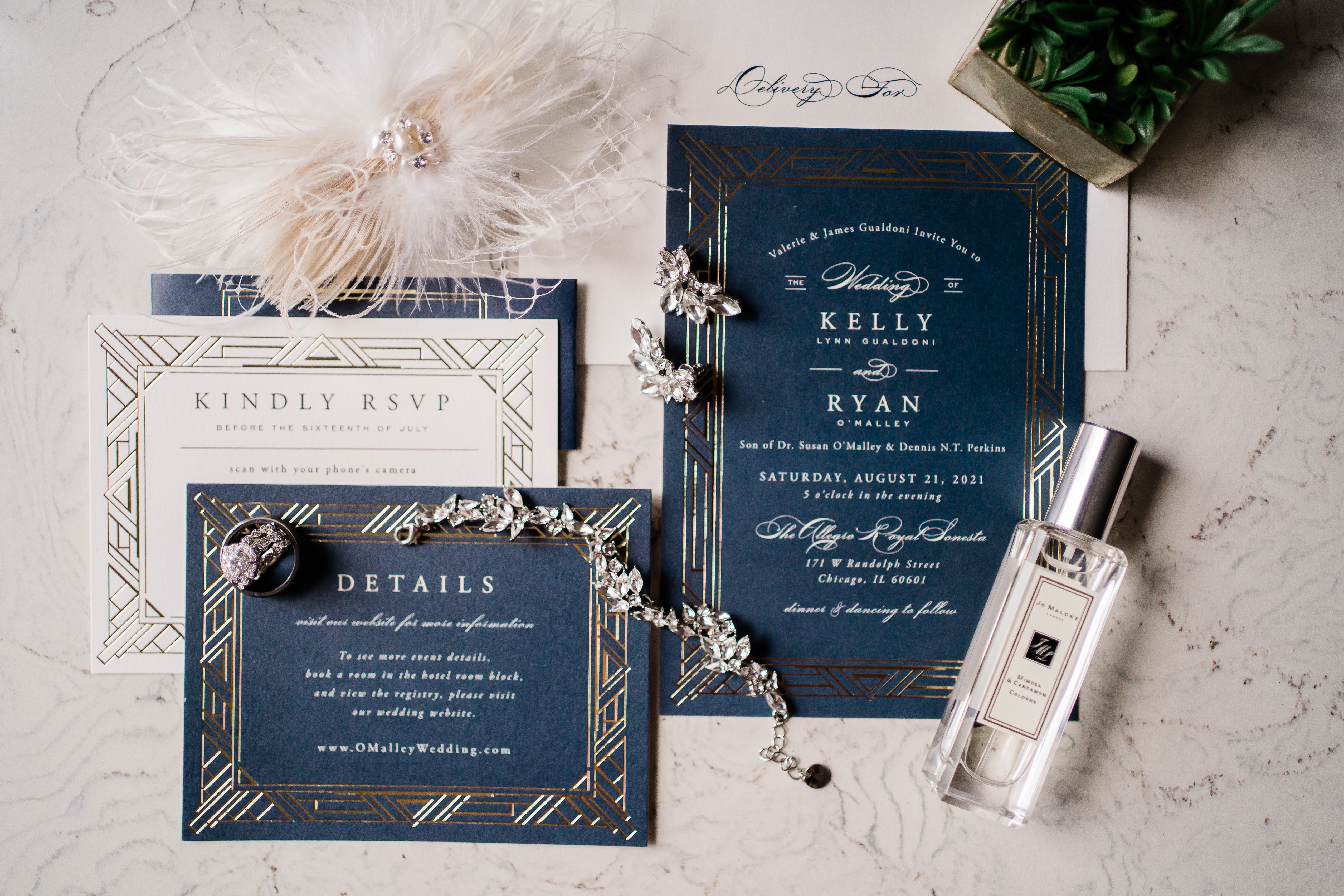 blue wedding invitations laid out with other wedding details on a white background for wedding flatlay photos