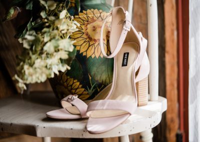brides wedding heels on a table with a floral bouquet at Fort Wayne wedding venue