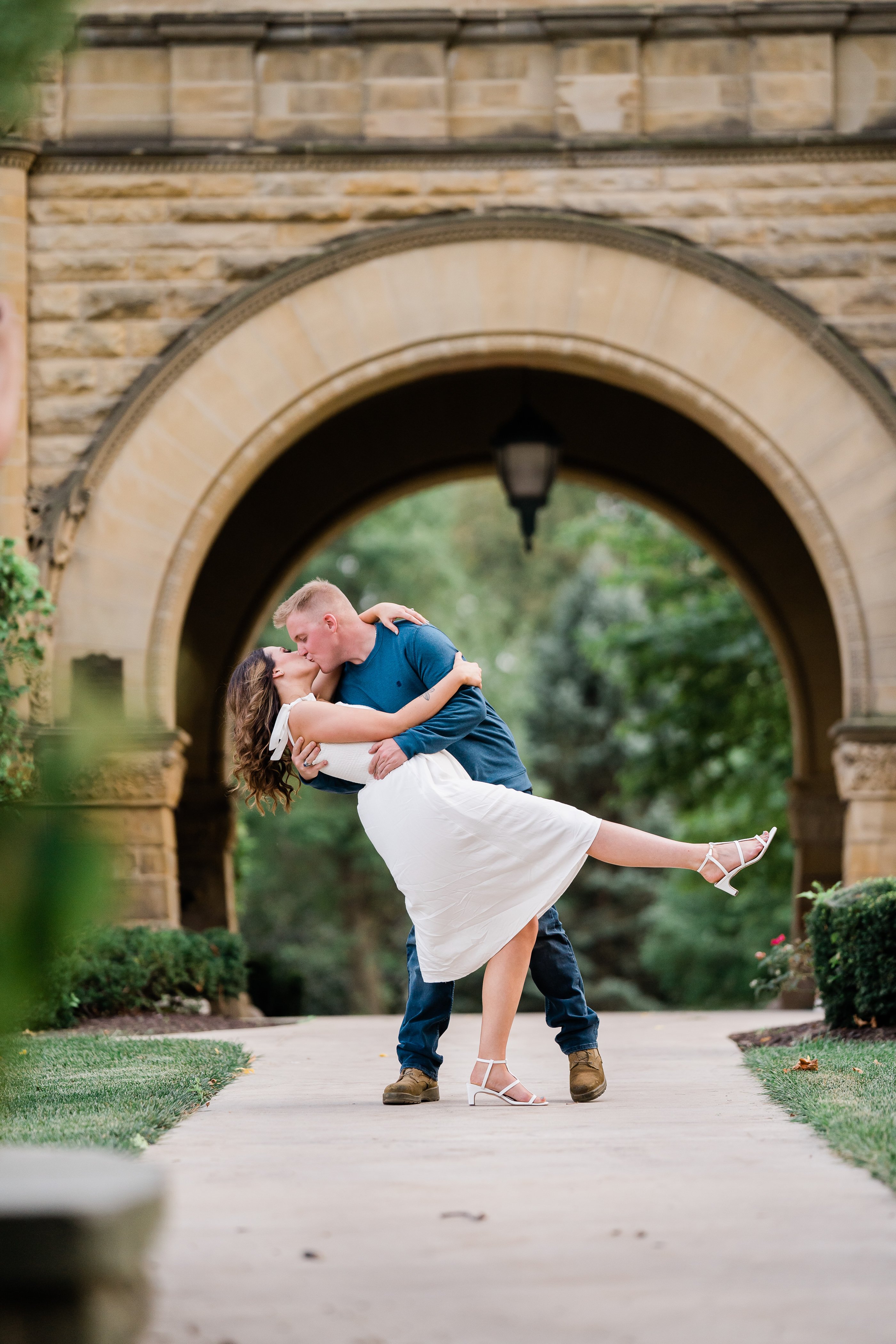man dipping his fiance backwards and kissing her at a luxury engagement shoot in Fort Wayne
