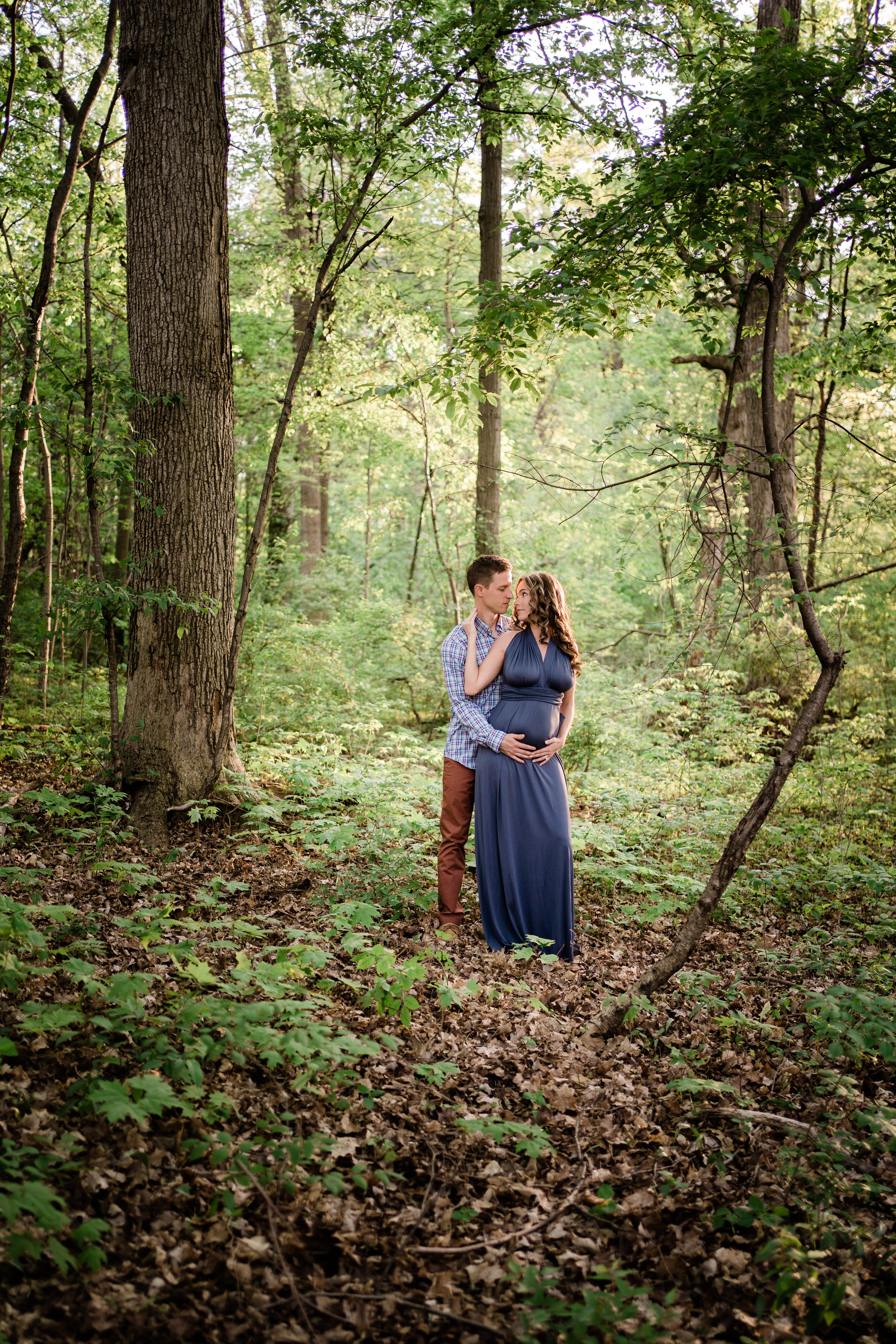 Fort Wayne maternity session in the woods with man and pregnant wife embracing