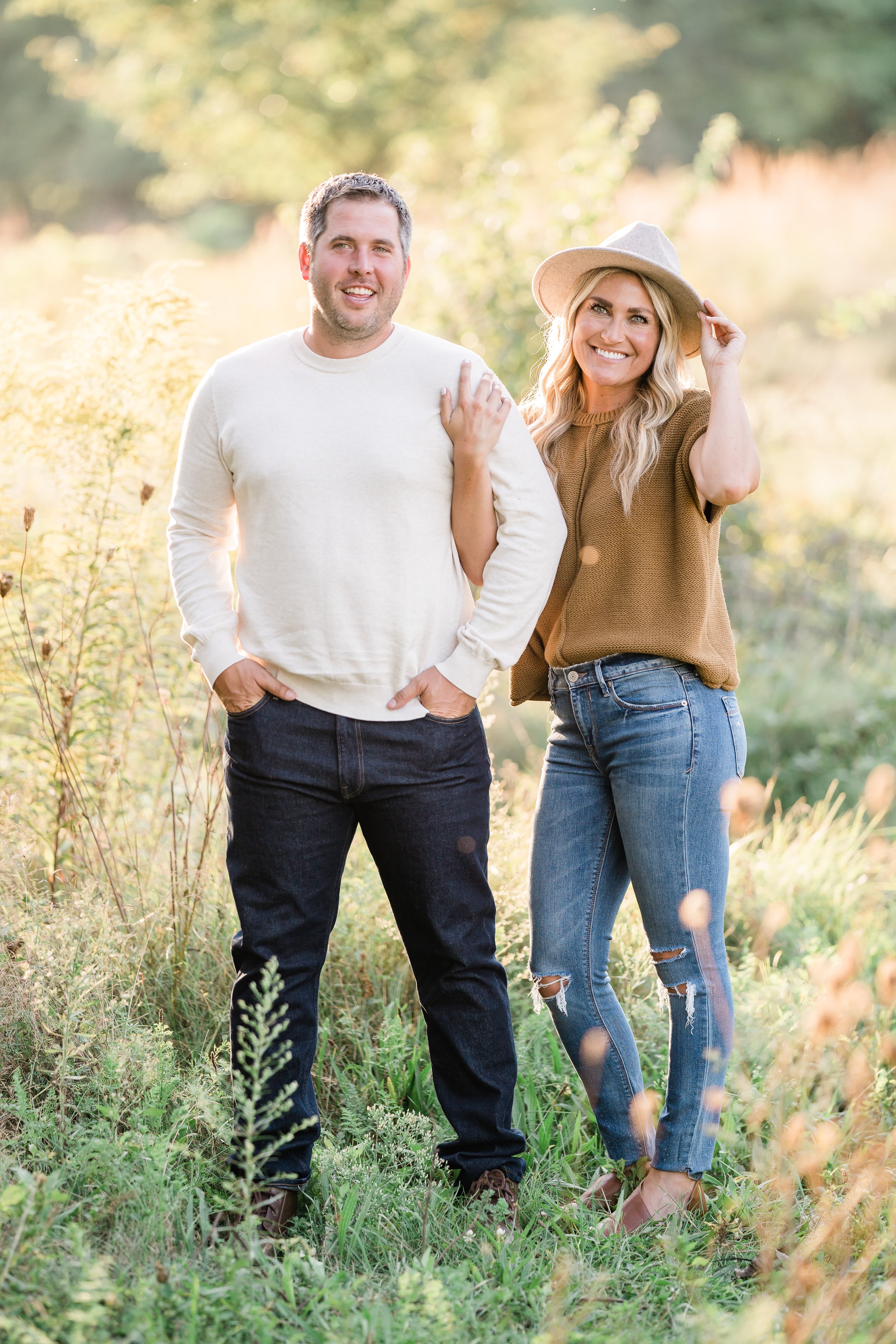 summer engagement photos with man and woman standing together in a field at sunset captured by Fort Wayne wedding photographers
