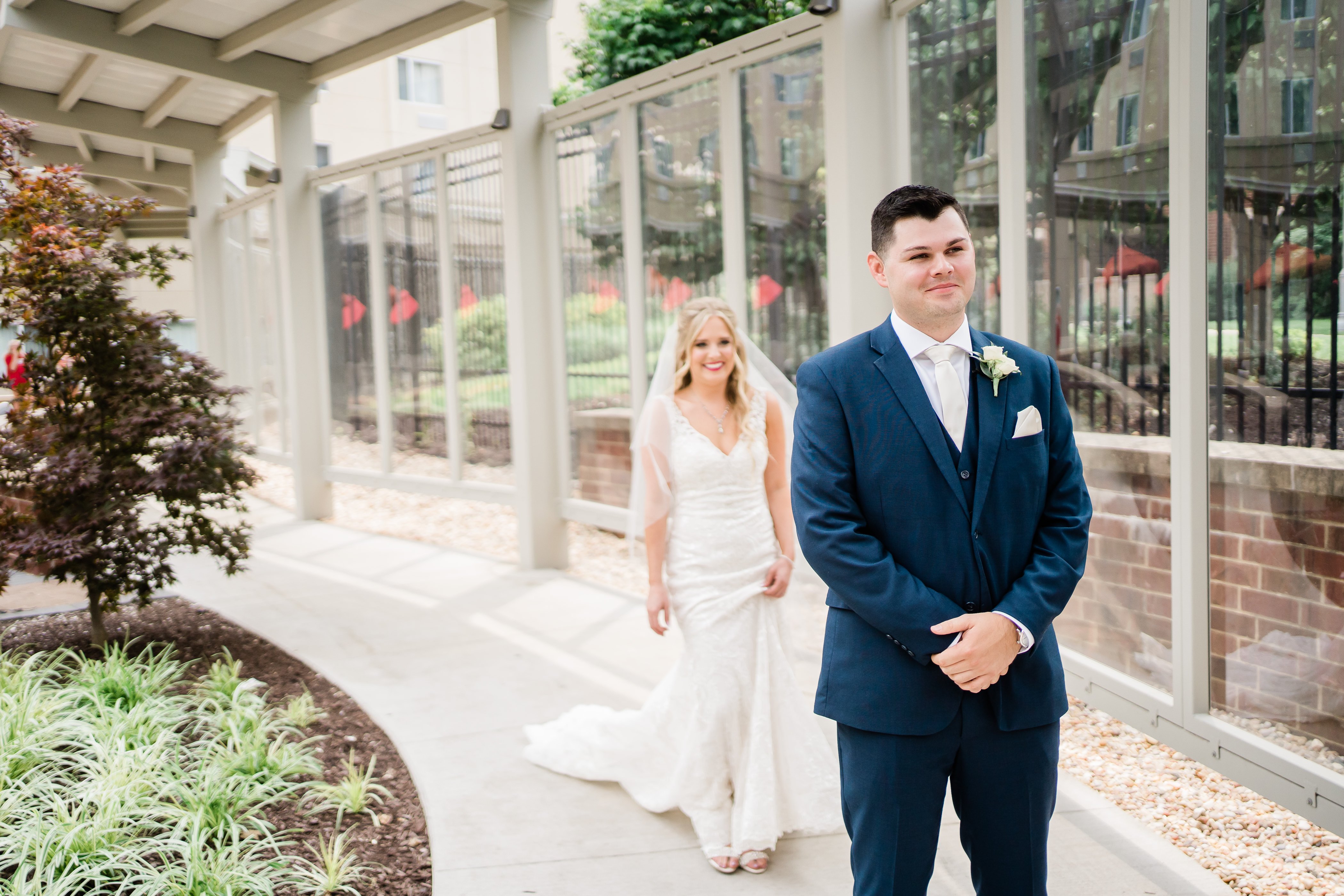 Fort Wayne wedding photographers capture bride walking up to her groom from behind him for their first look