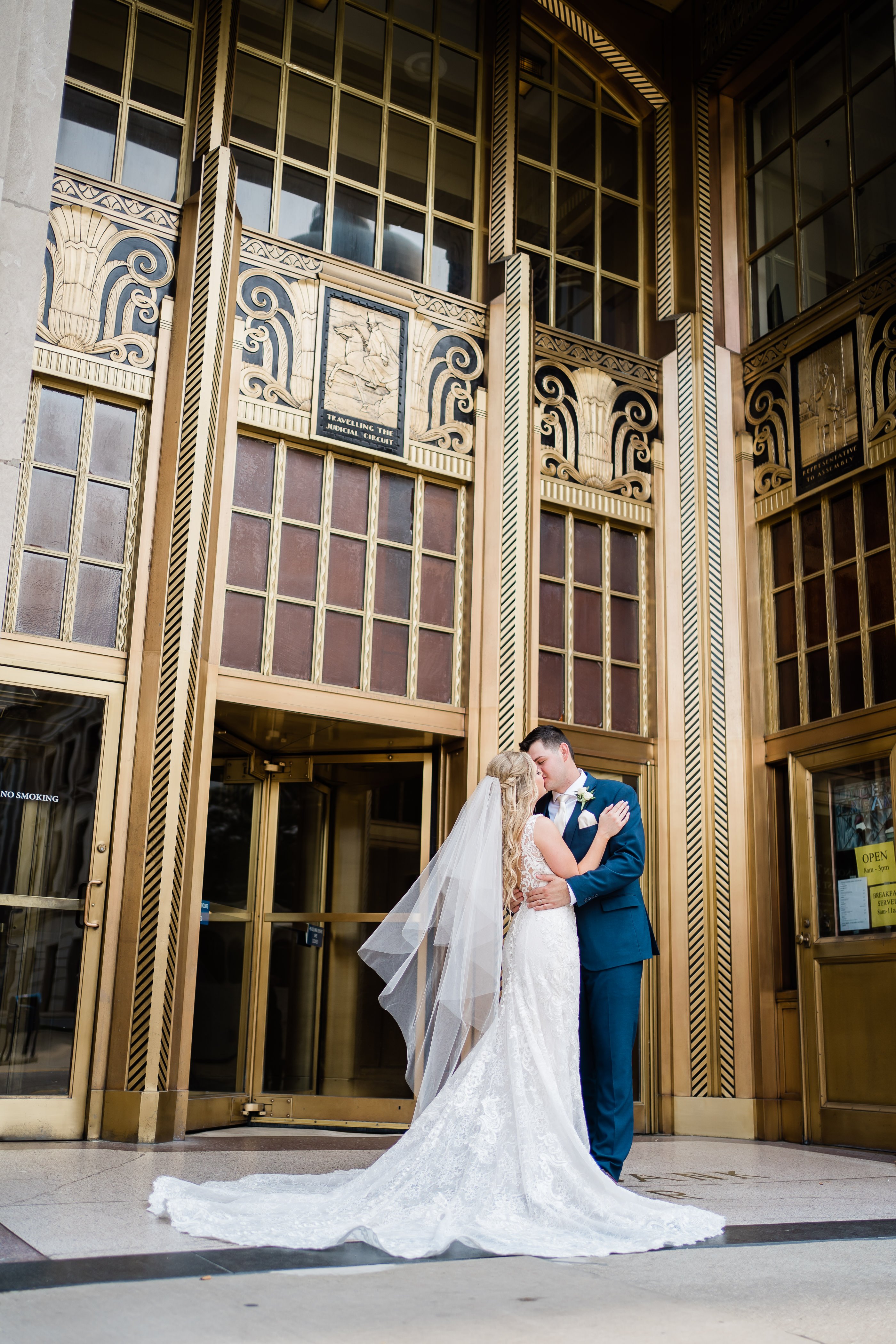 bride and groom kissing outside of their wedding venue