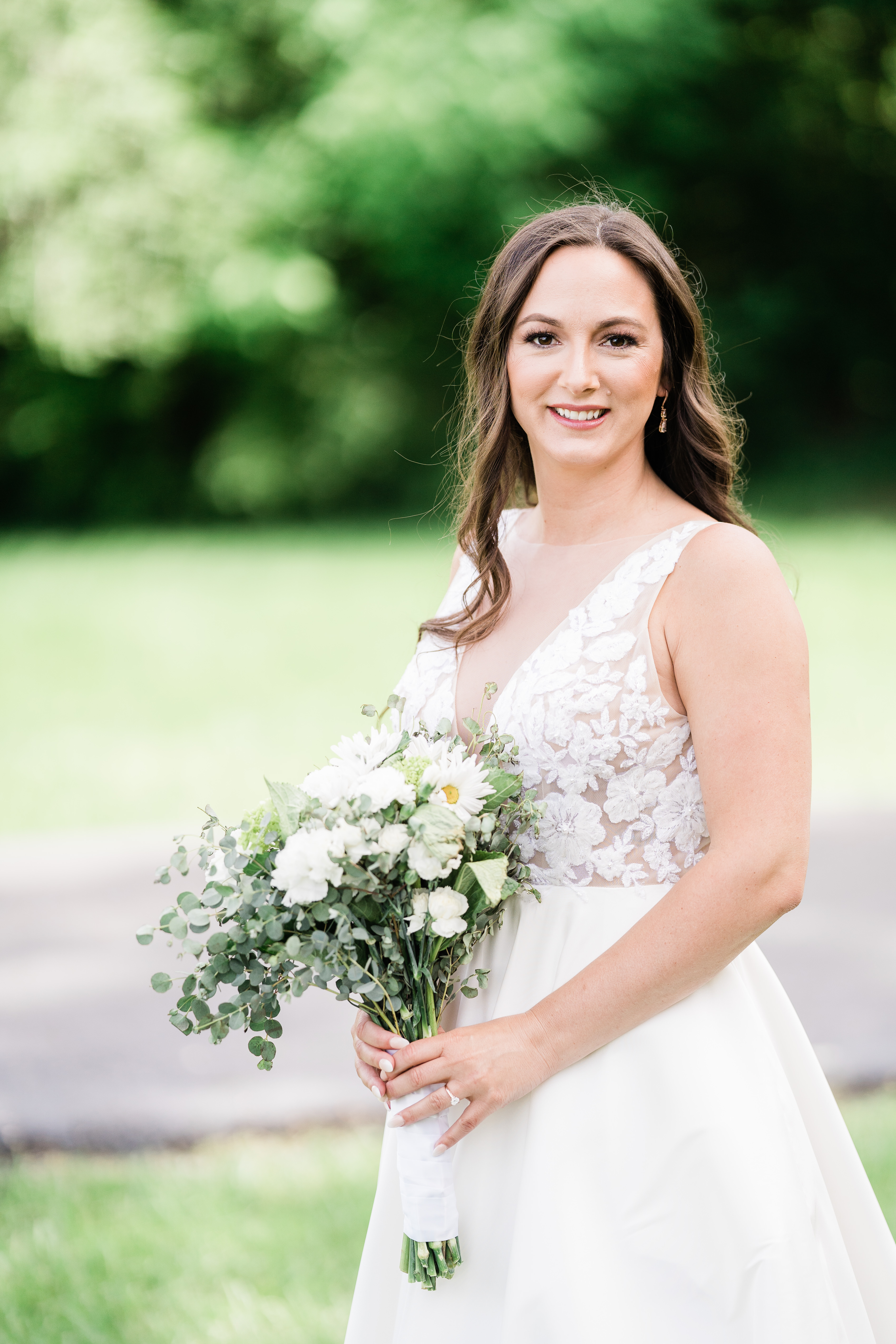 bride in a white lace wedding dress holding her floral bridal bouquet taken by Fort Wayne wedding photographers