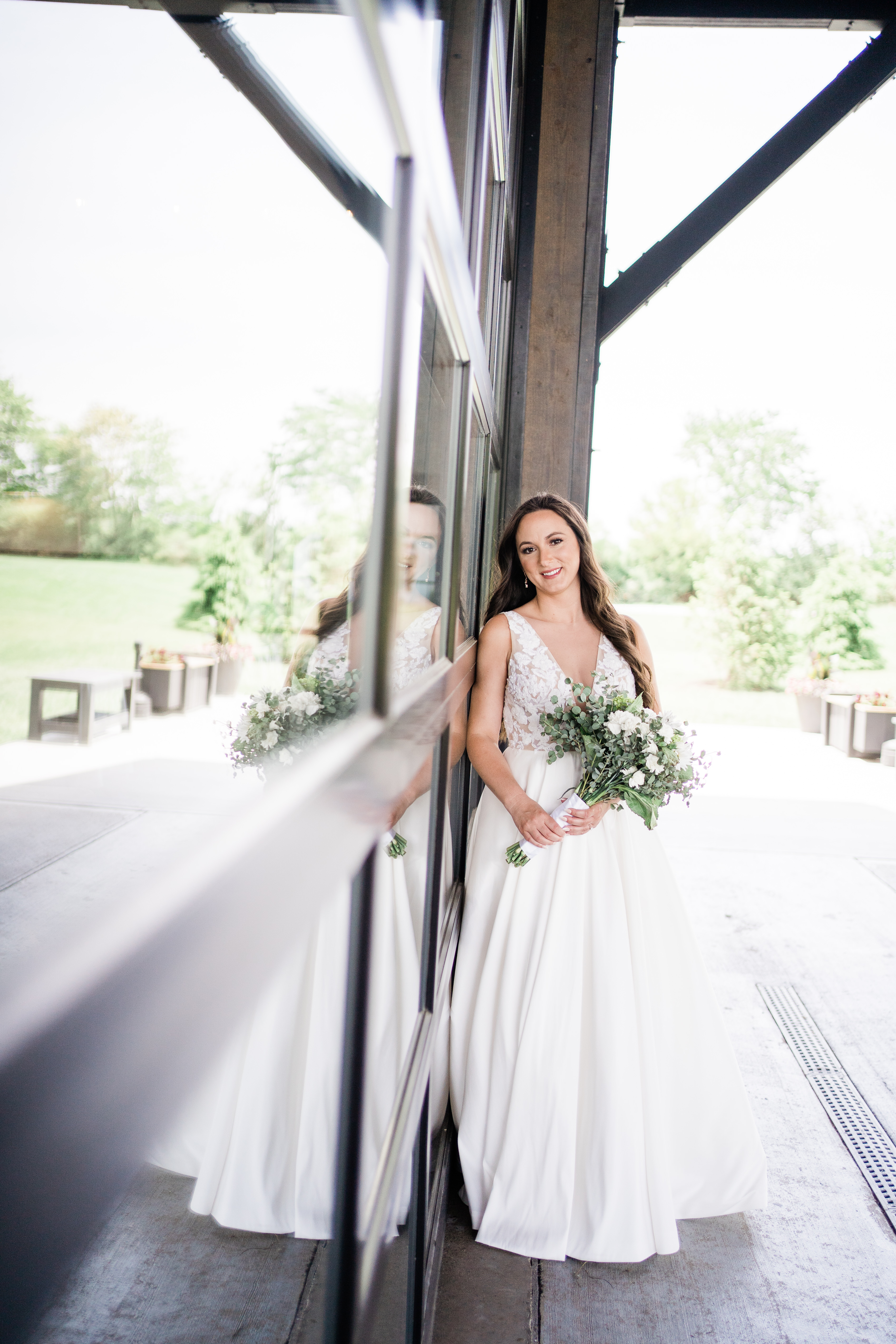 bride leaning against the wall of her wedding venue taken by Fort Wayne wedding photographer