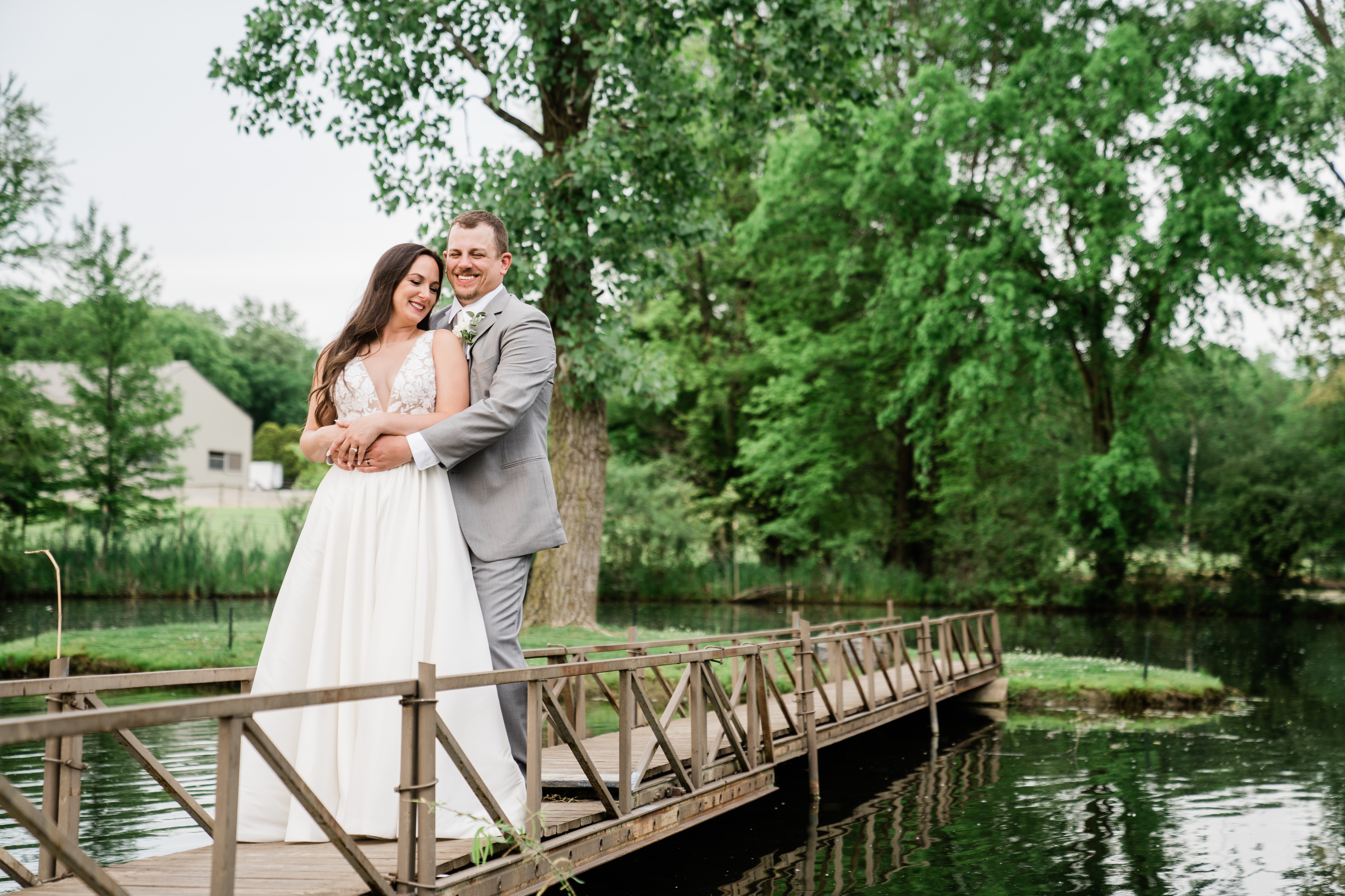 bride and groom embracing on a bridge at their outdoor Fort Wayne wedding venue