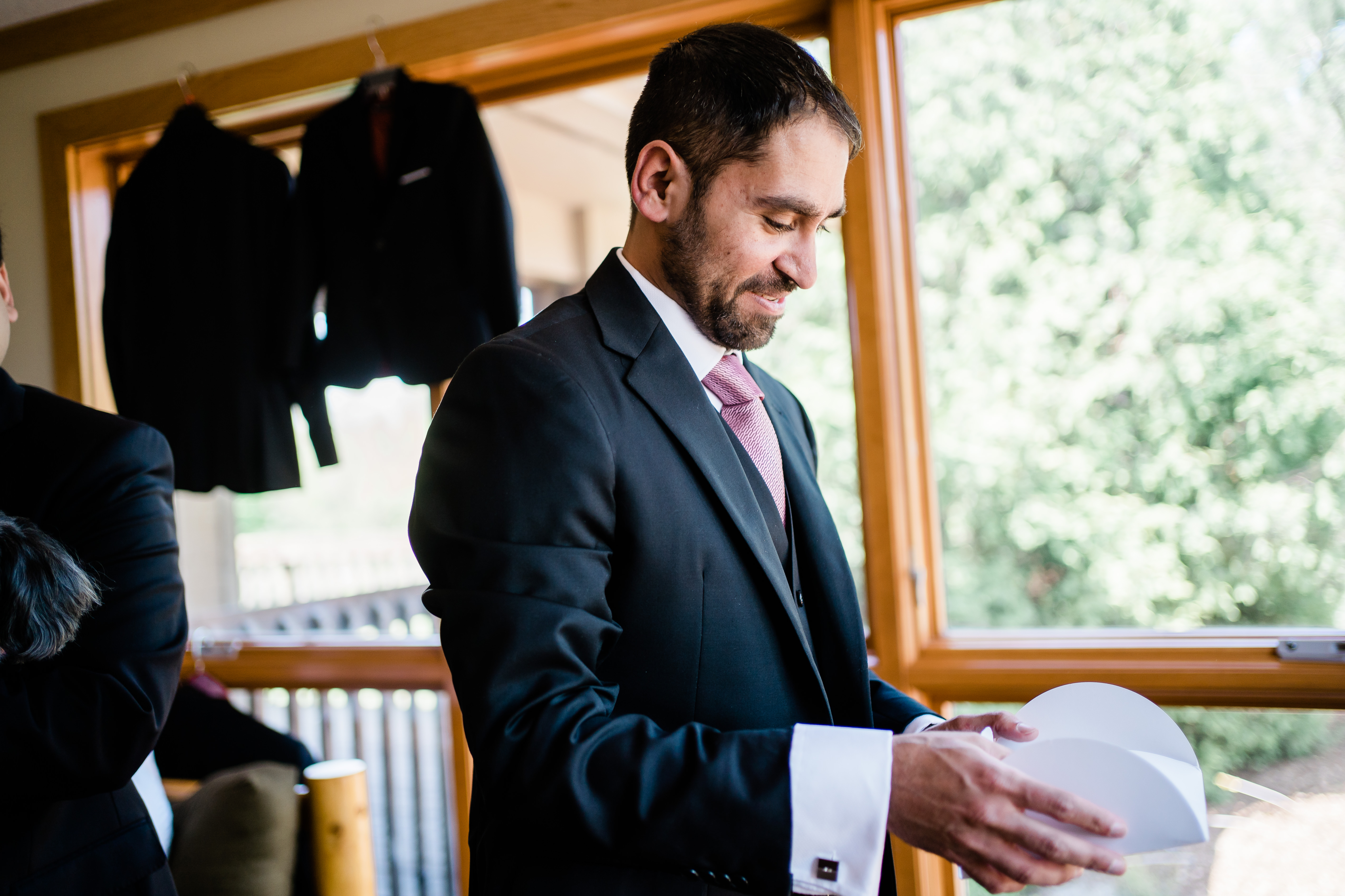 groom opening a gift from his bride before the ceremony in his suite