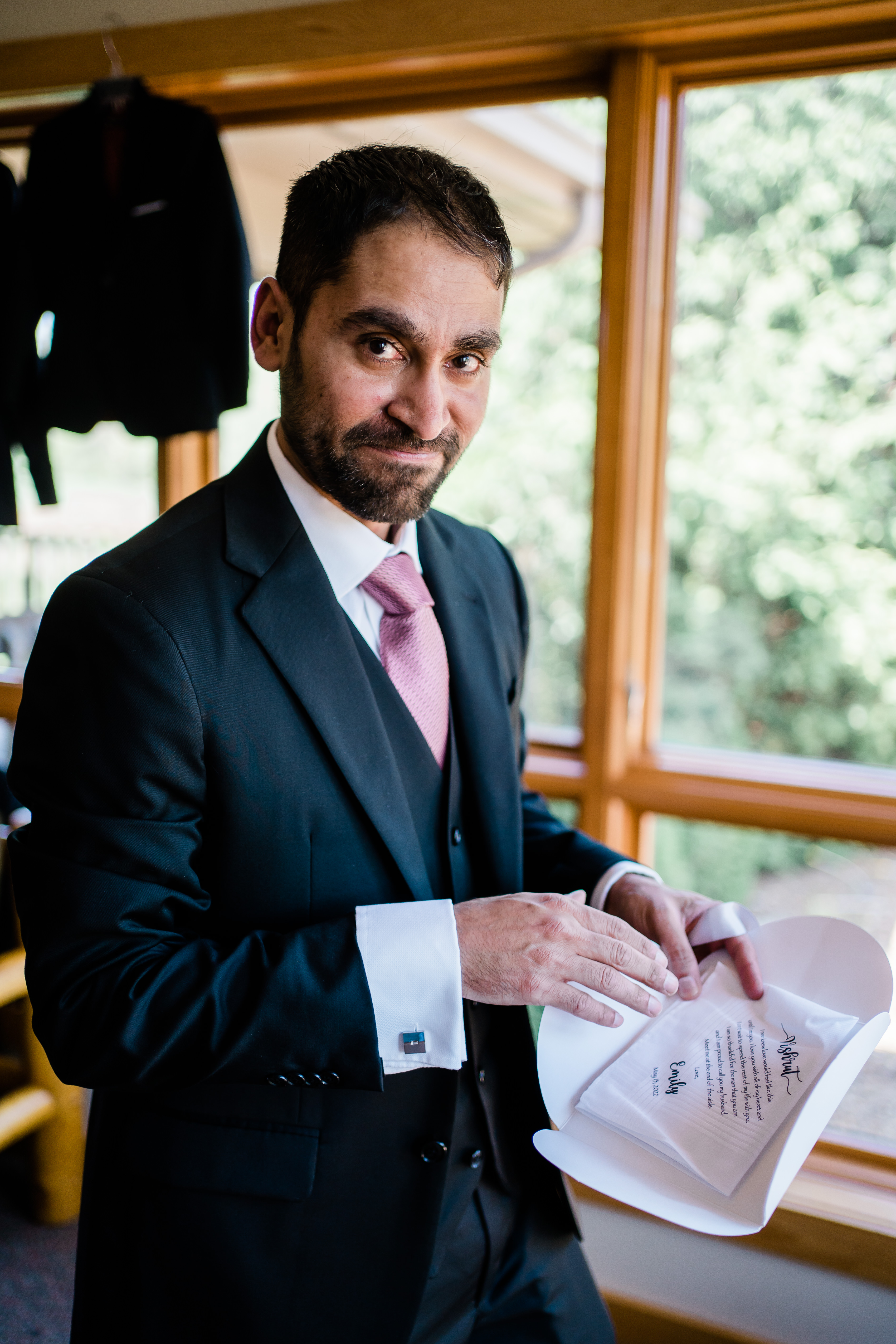 groom opening a gift from his bride as he gets ready for his wedding ceremony