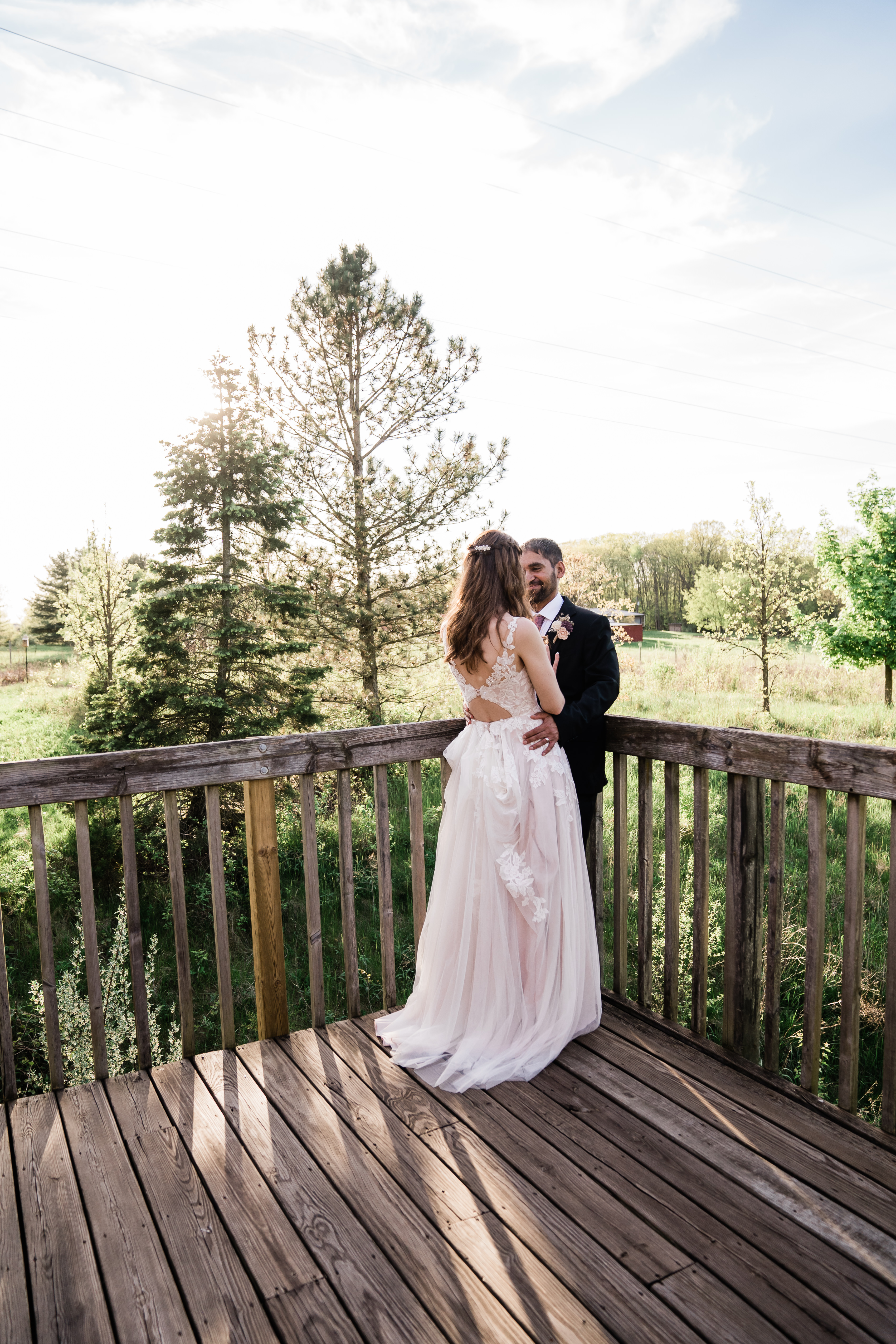 bride and groom hugging on a deck for their outdoor wedding in Fort Wayne wedding