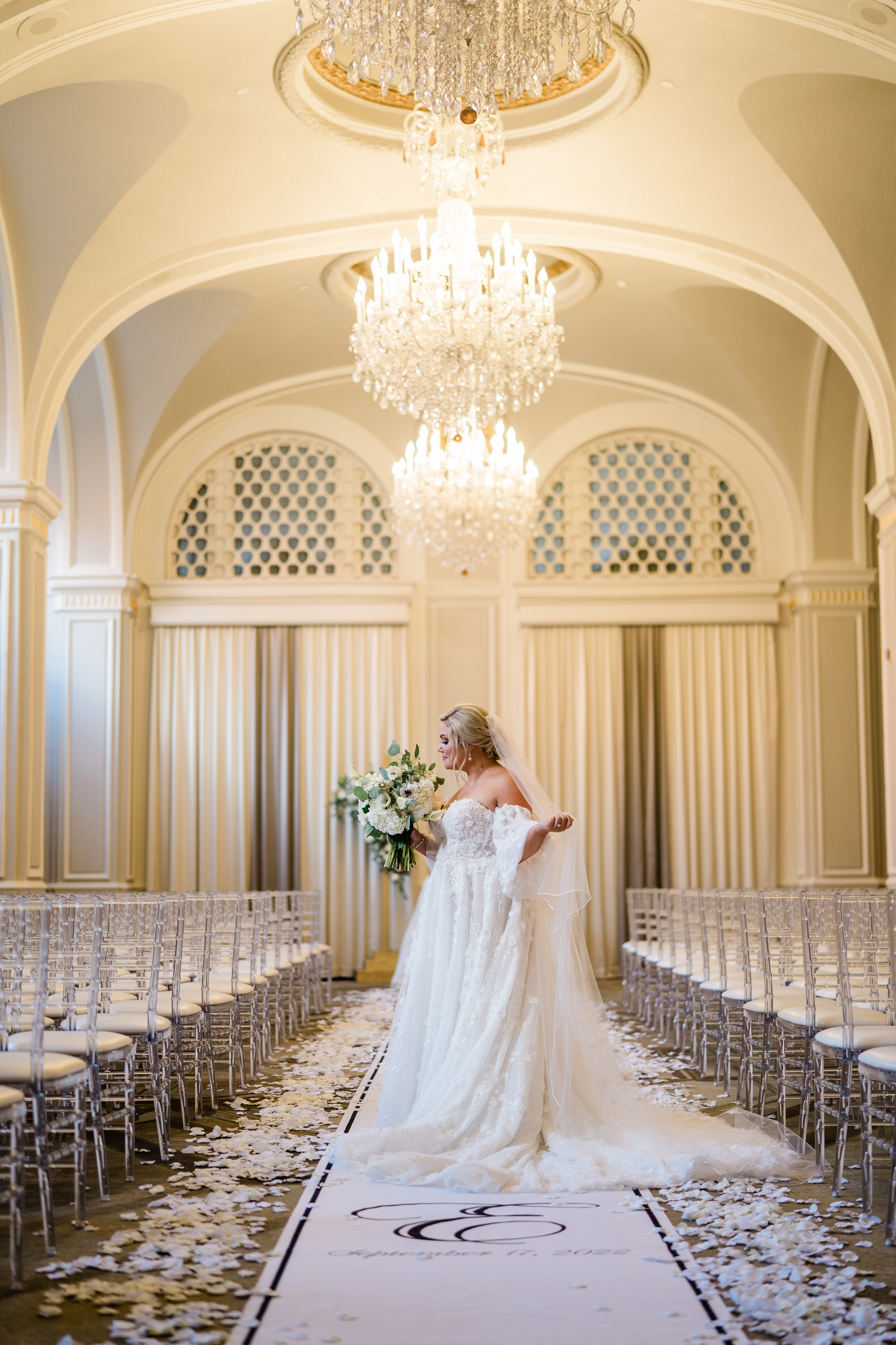bride posingin a white ceremony hall with silver accents
