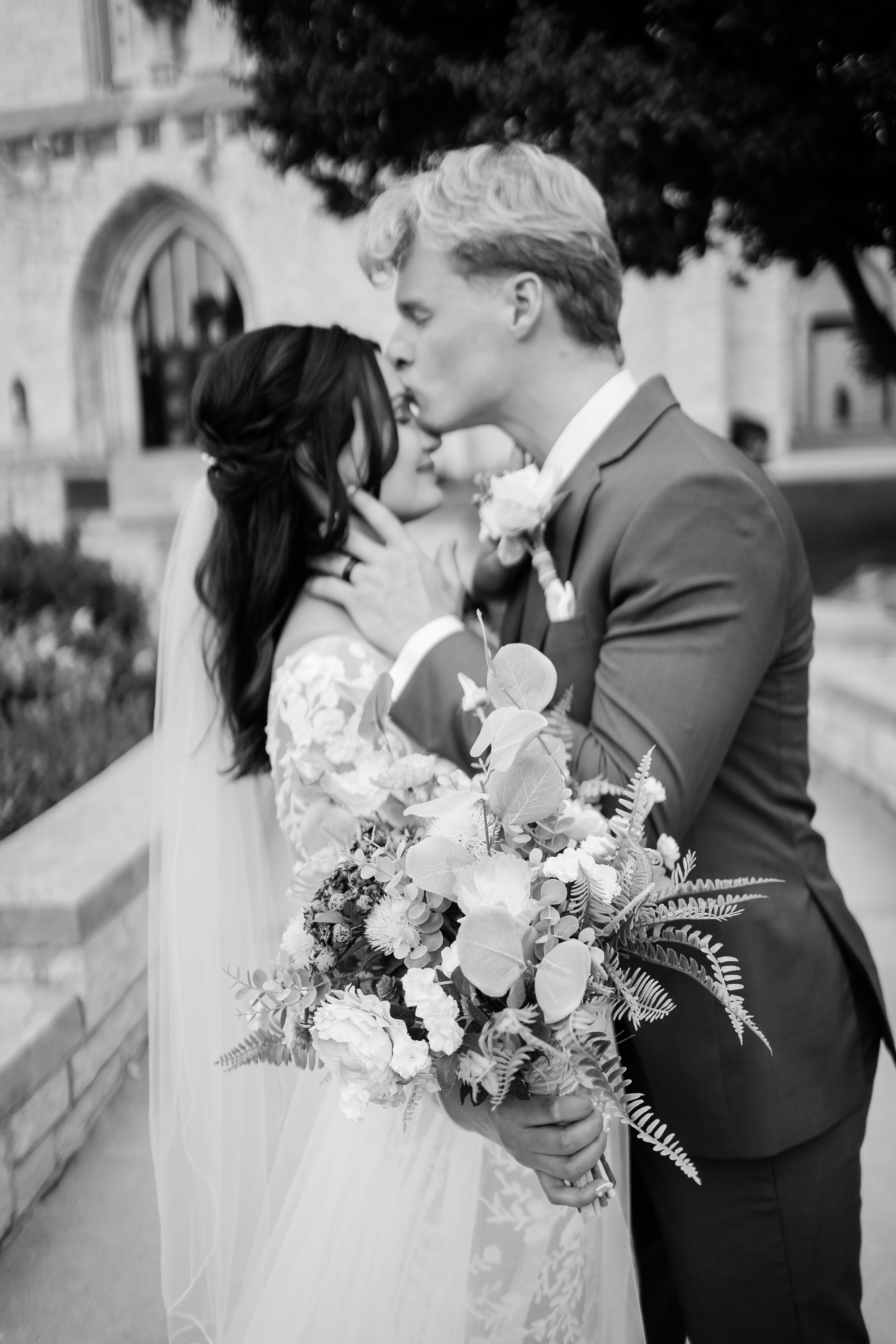 Fort Wayne wedding photographers photograph groom kissing bride on the forehead for their wedding portraits in Fort Wayne wedding venue