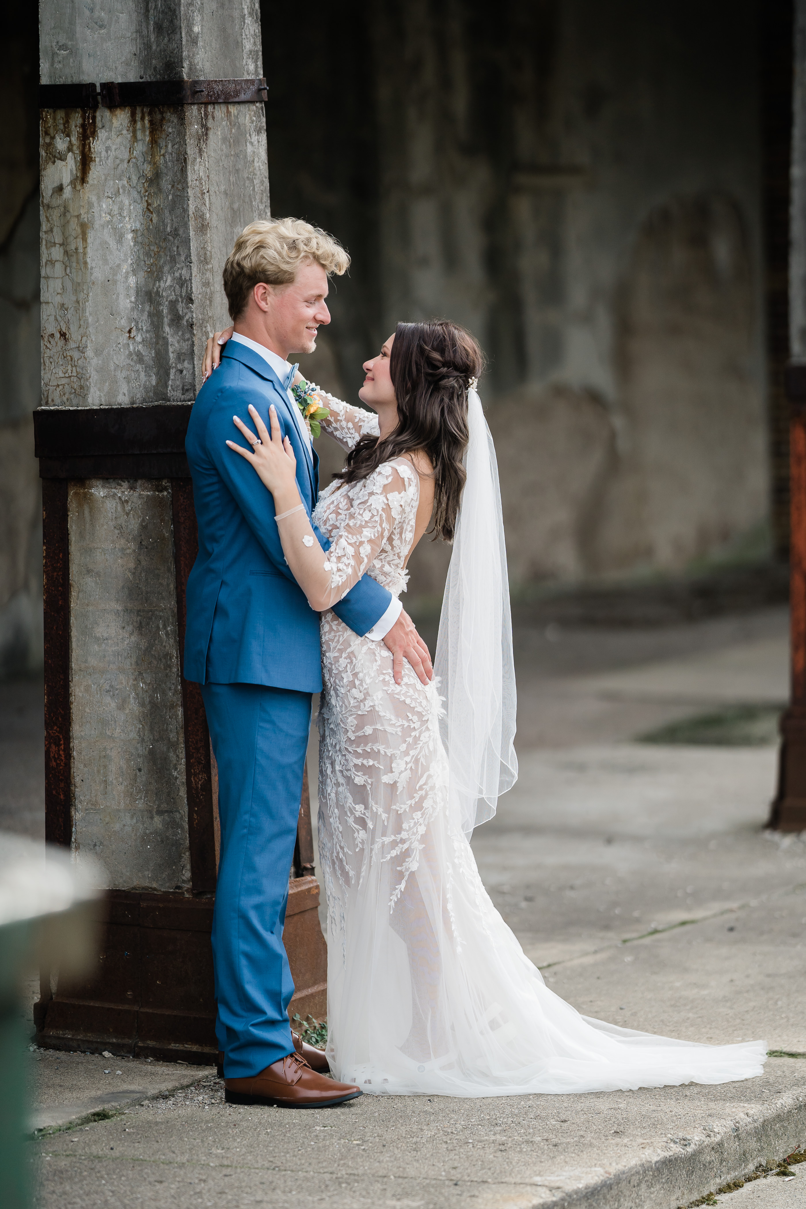bride and groom embracing one another and smile outside of train station wedding venue in Fort Wayne photographed by Fort Wayne wedding photographers