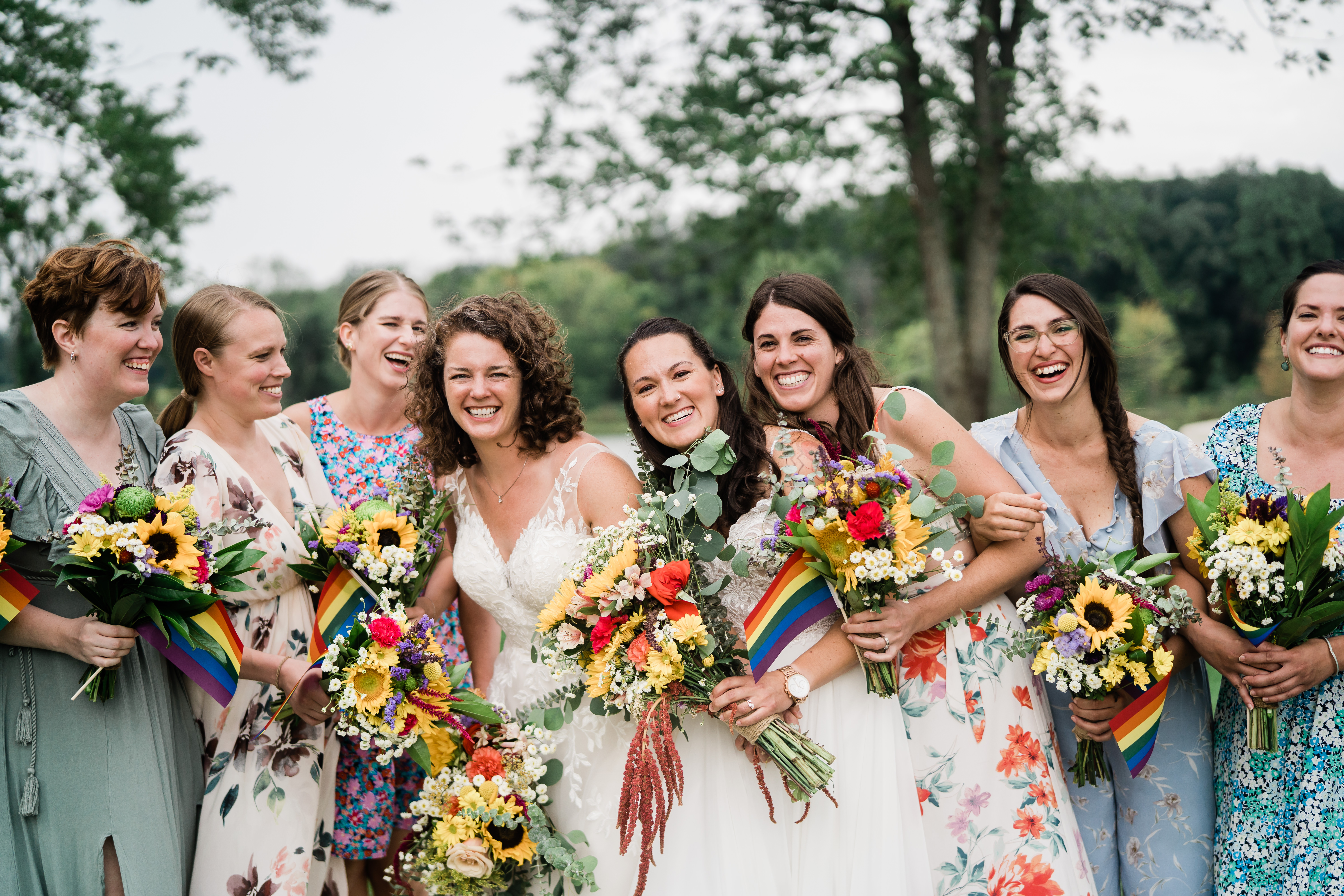 brides laughing and celebrating with wedding party