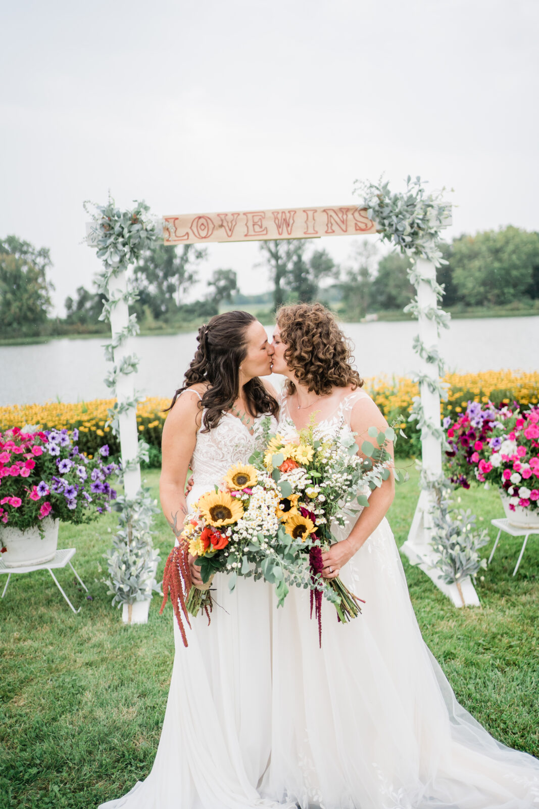 brides kissing at alter after outdoor wedding ceremony