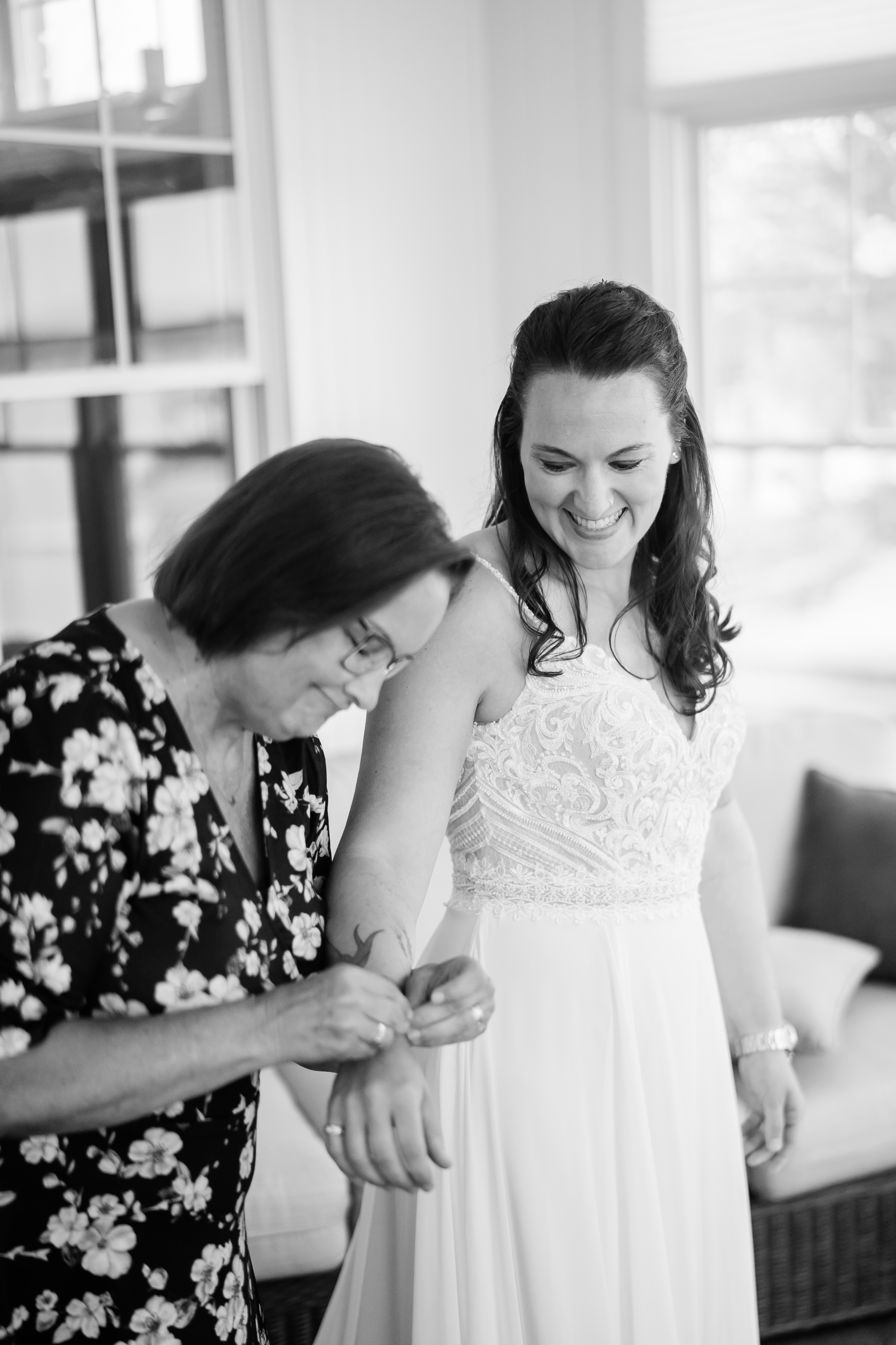 mother helping bride with jewelry day of wedding