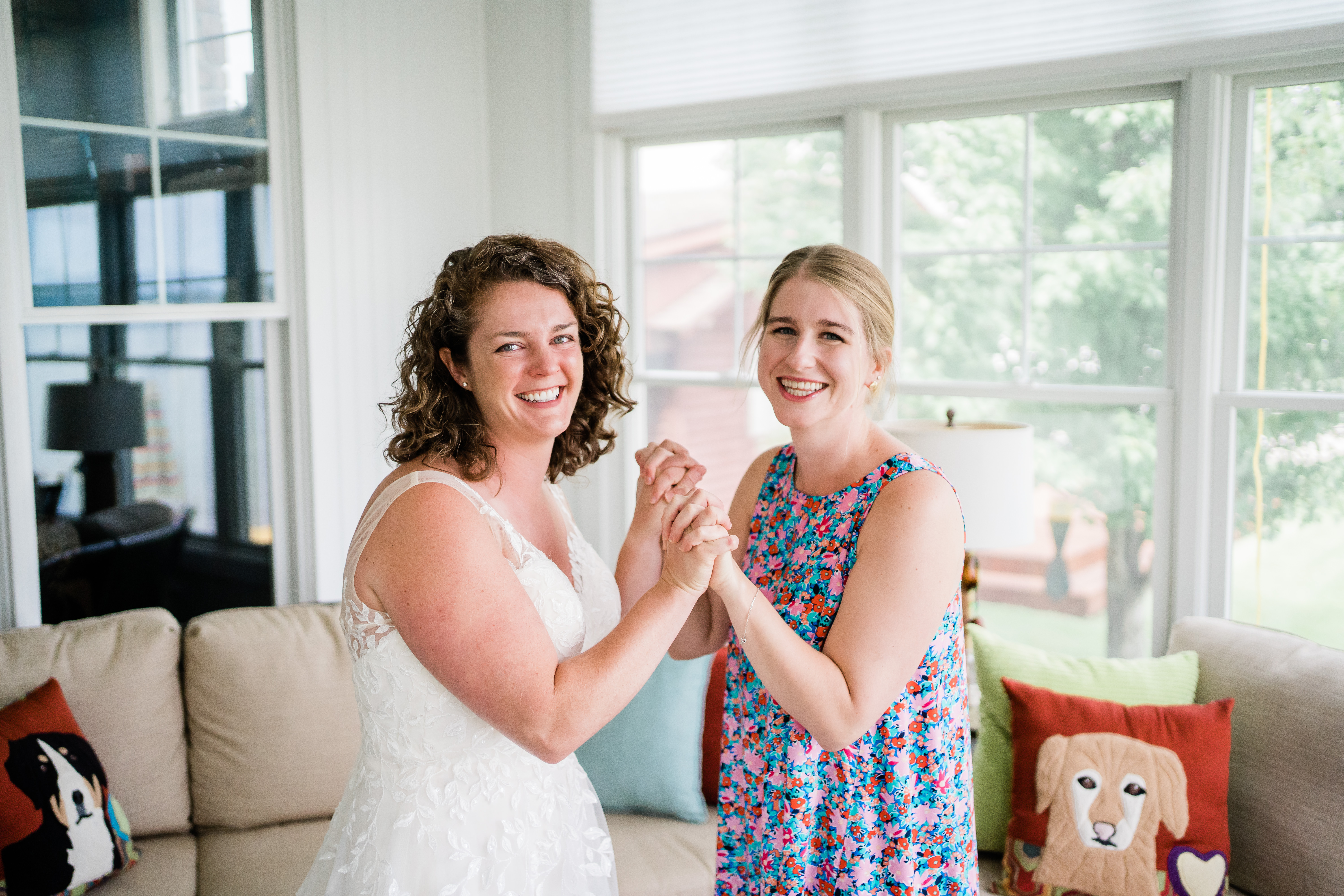 bride holding hands with friend celebrating