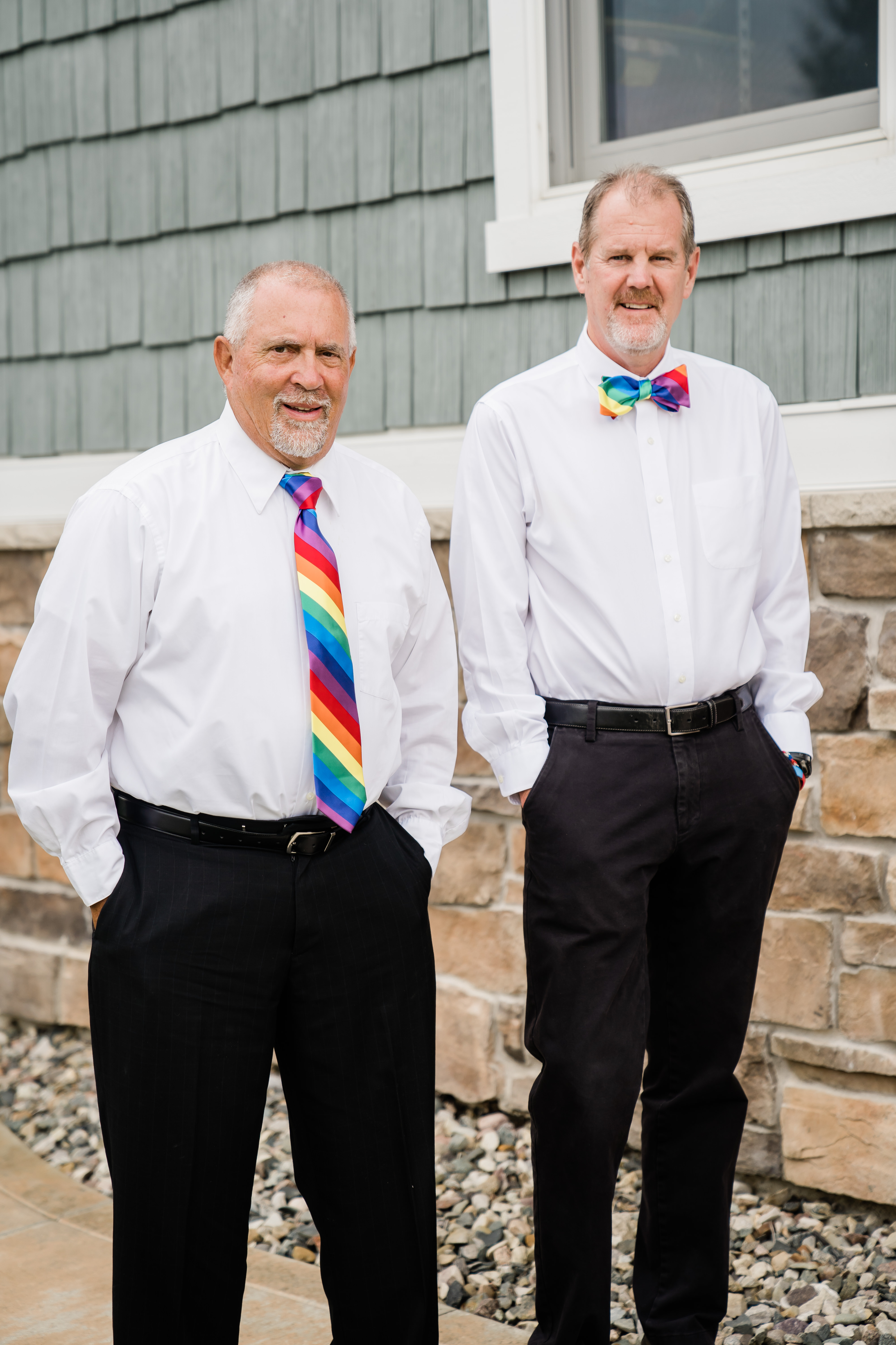 fathers of brides standing together wearing rainbow bow tie and tie