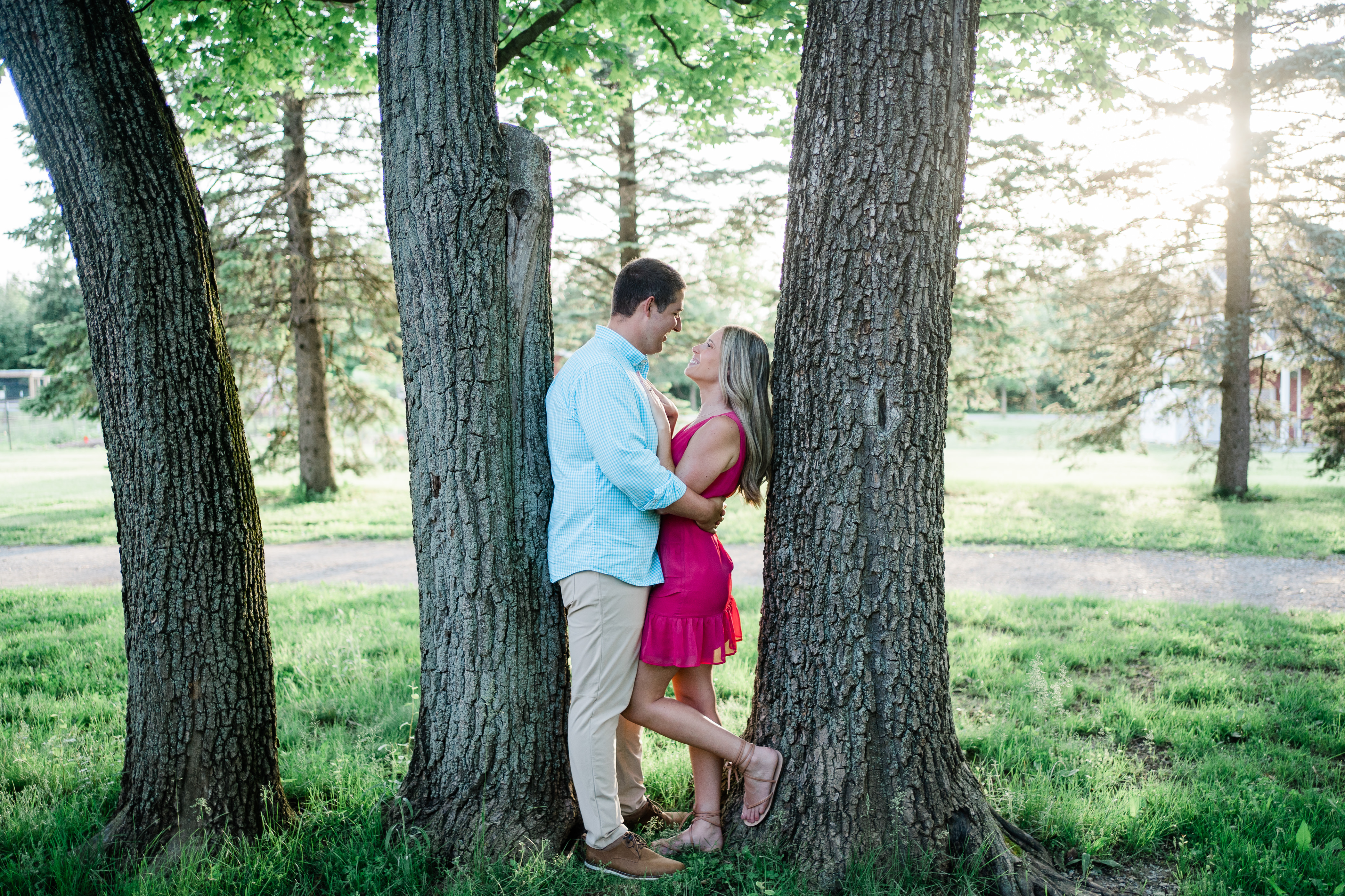 Fort Wayne wedding photographer captures newly engaged couple kissing in between trees