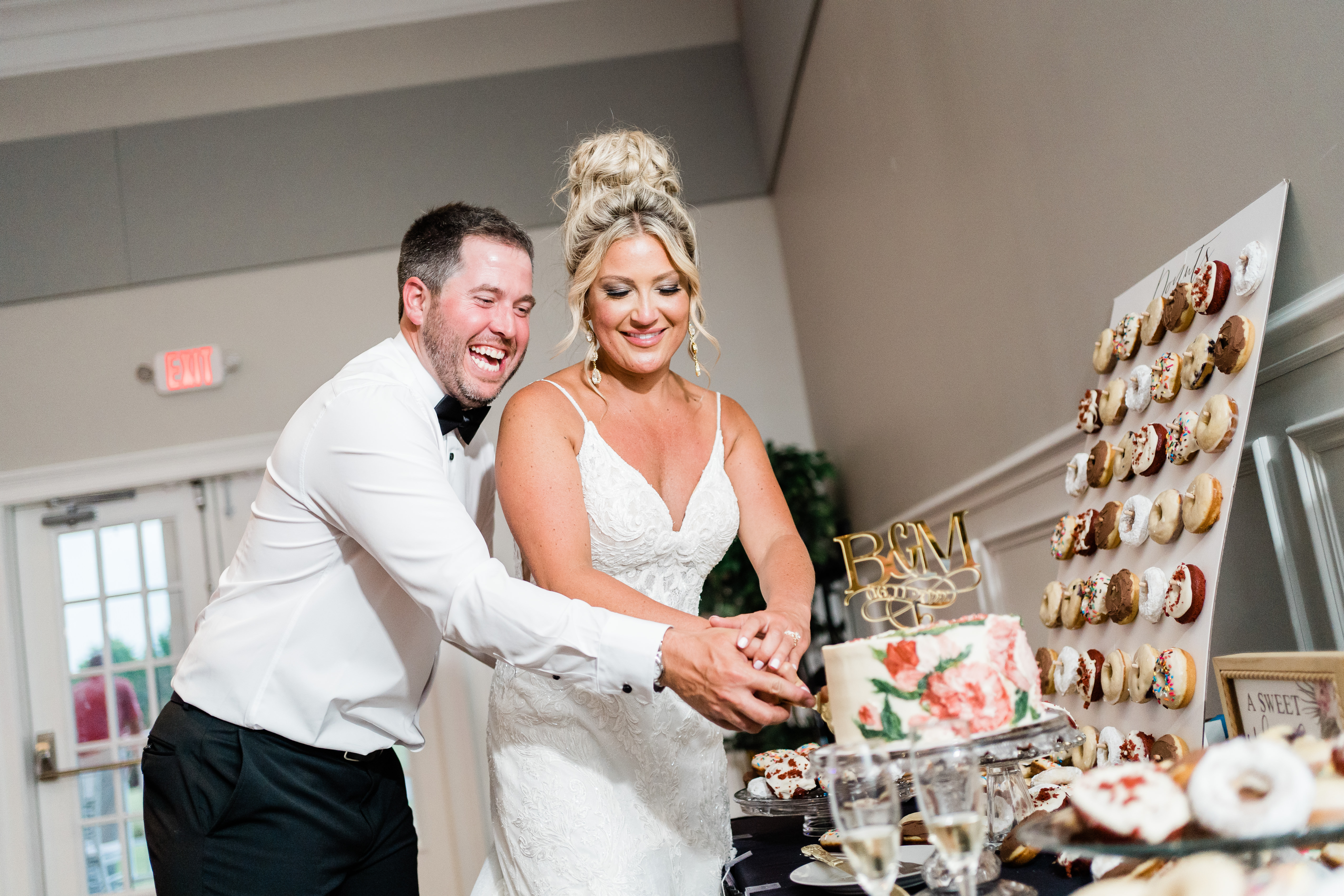 Fort Wayne wedding photographers capture bride and groom cutting cake as husband and wife