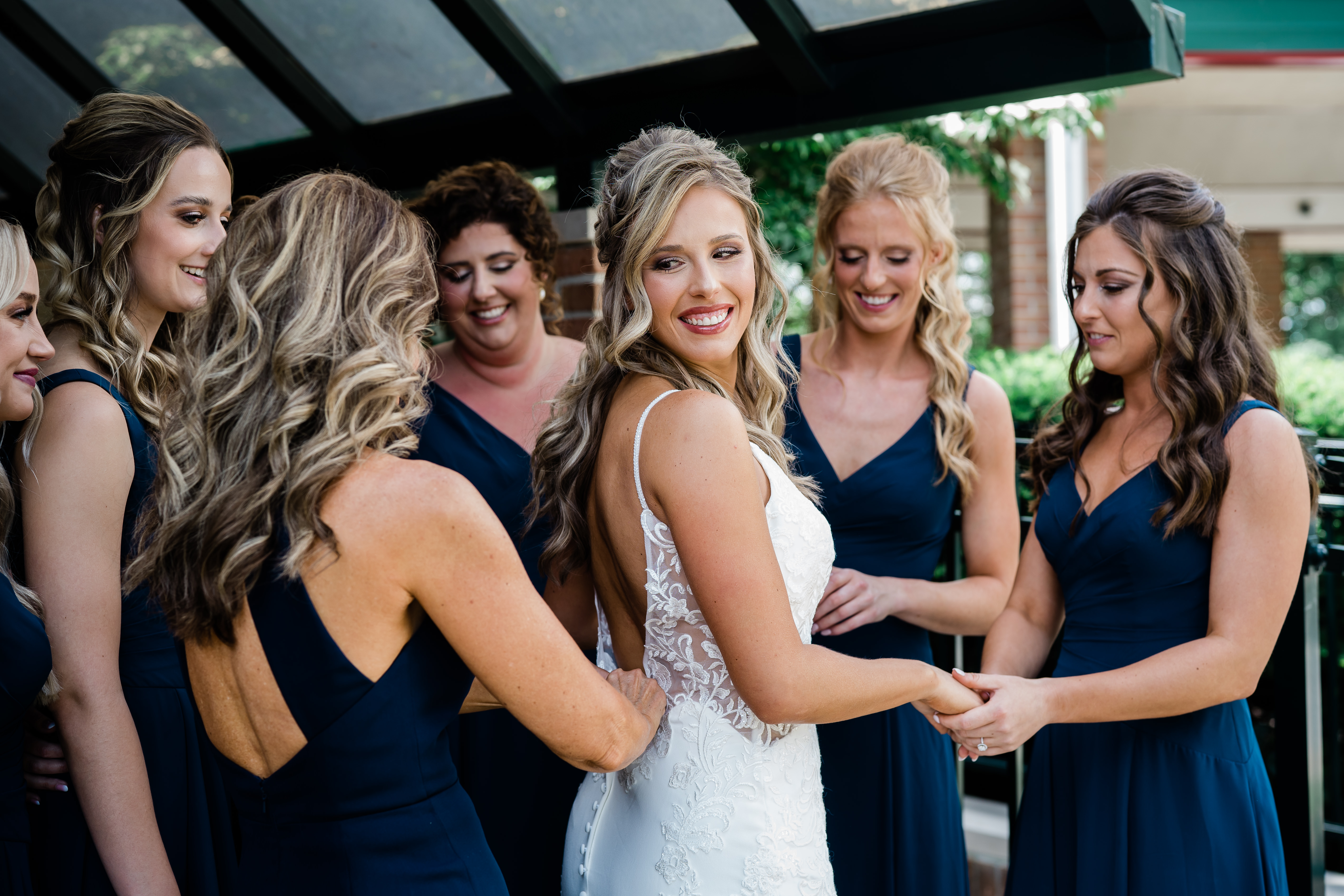 Fort Wayne wedding photographers capture bride looking over shoulder at mother smiling