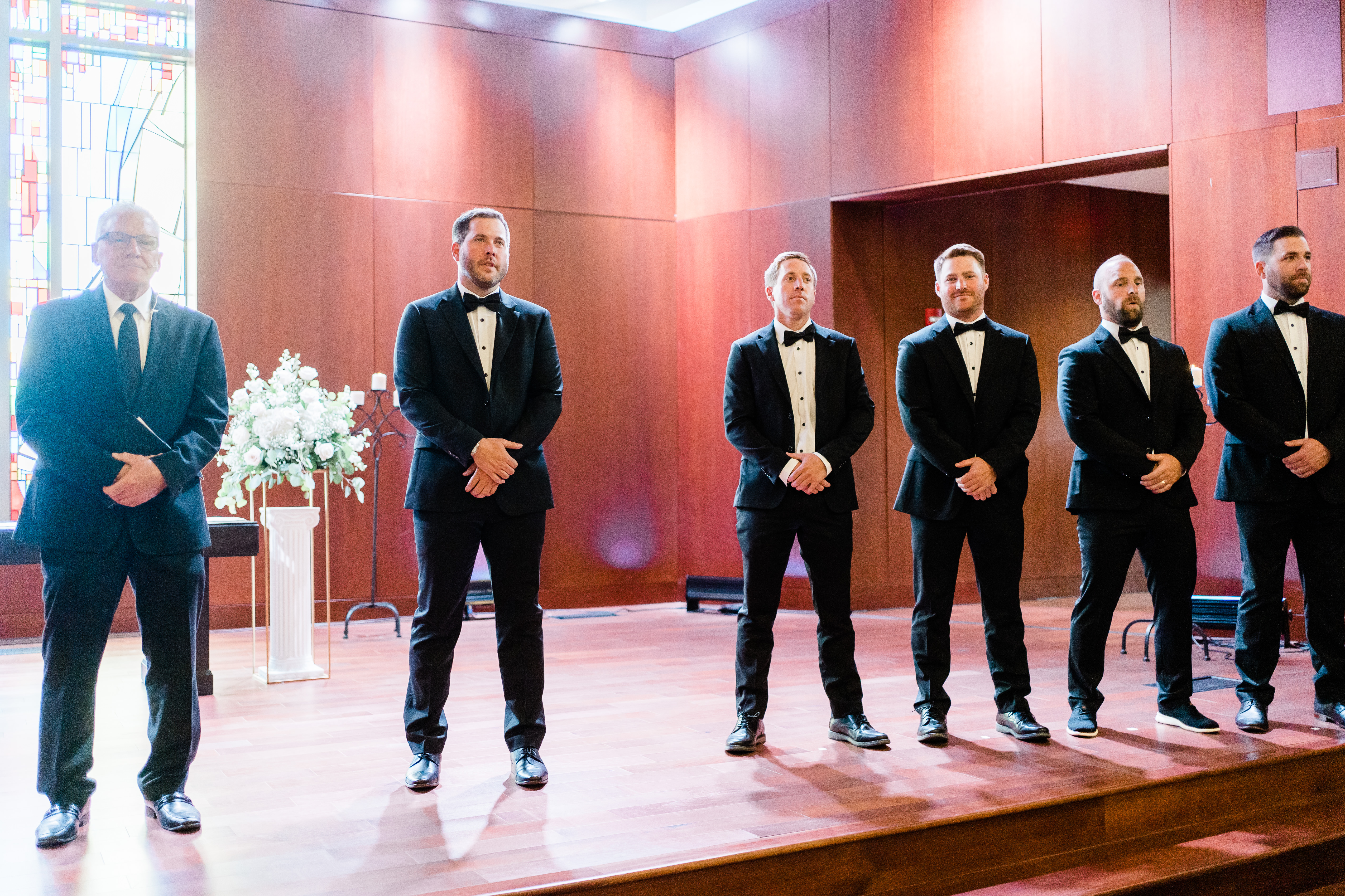 Fort Wayne wedding photographer captures groom standing with groomsmen waiting for bride to walk down aisle