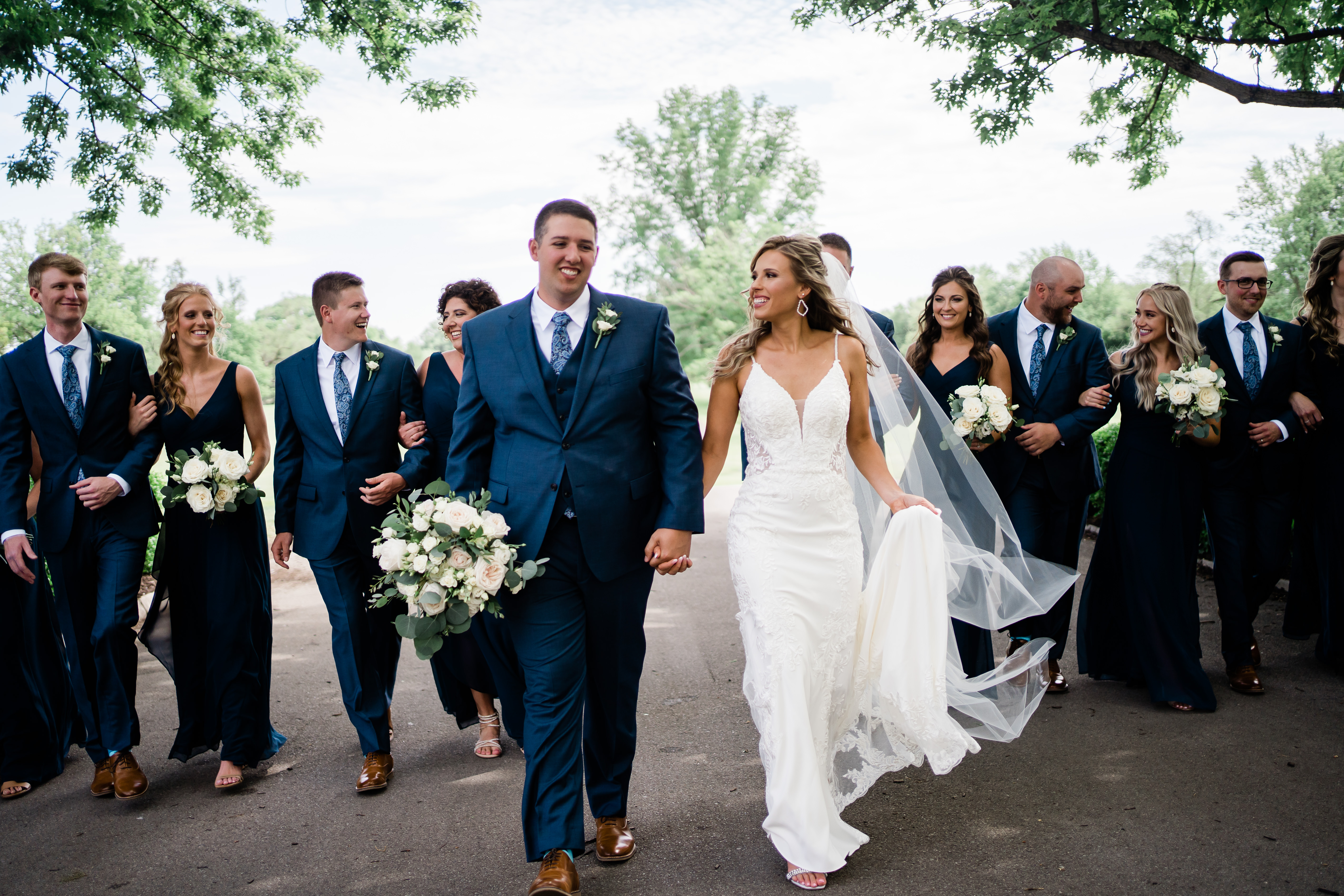 Fort wayne wedding photographers capture bride and groom walking with wedding party