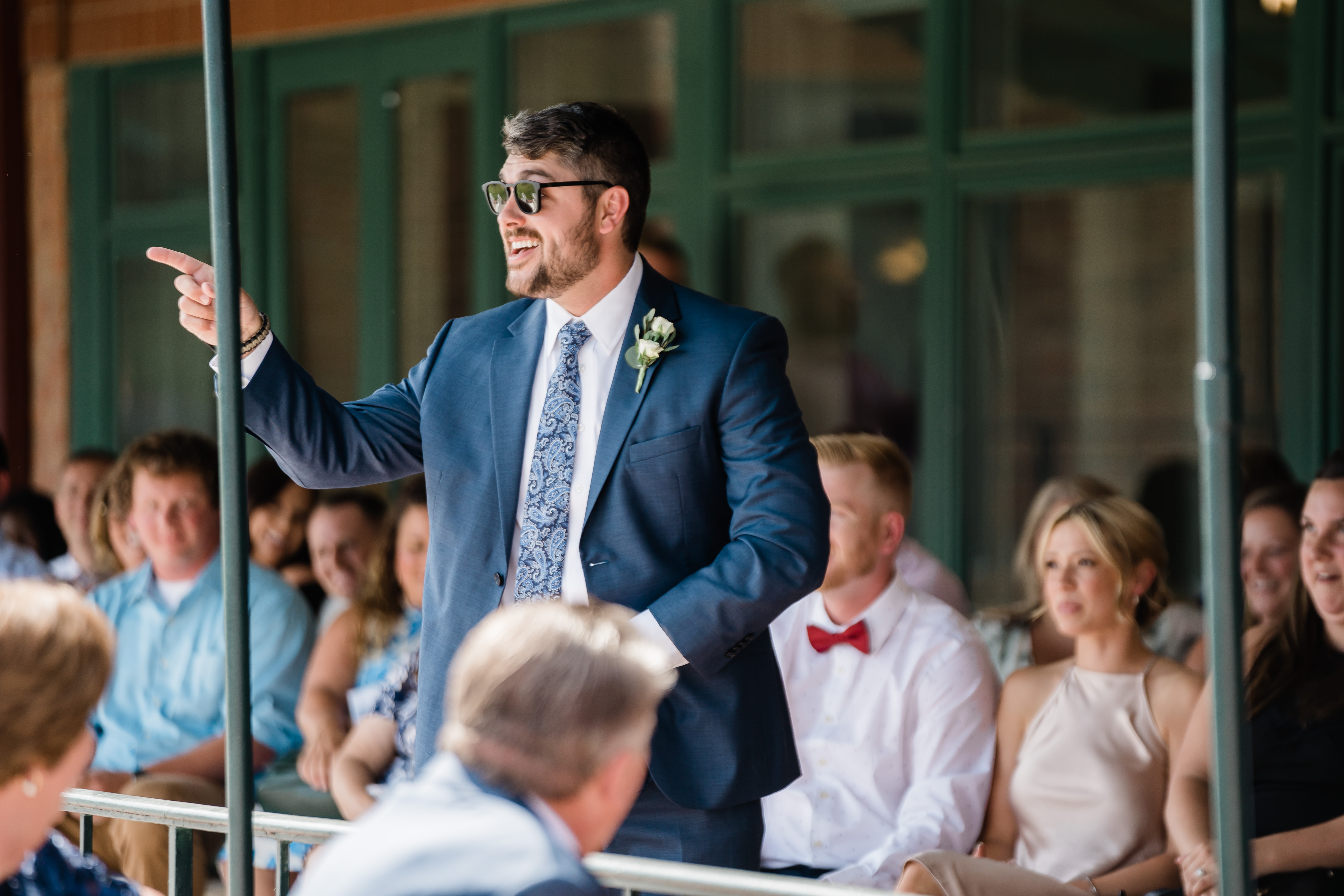 Fort Wayne wedding photographers capture flower guy walking down aisle wearing sunglasses throwing petals