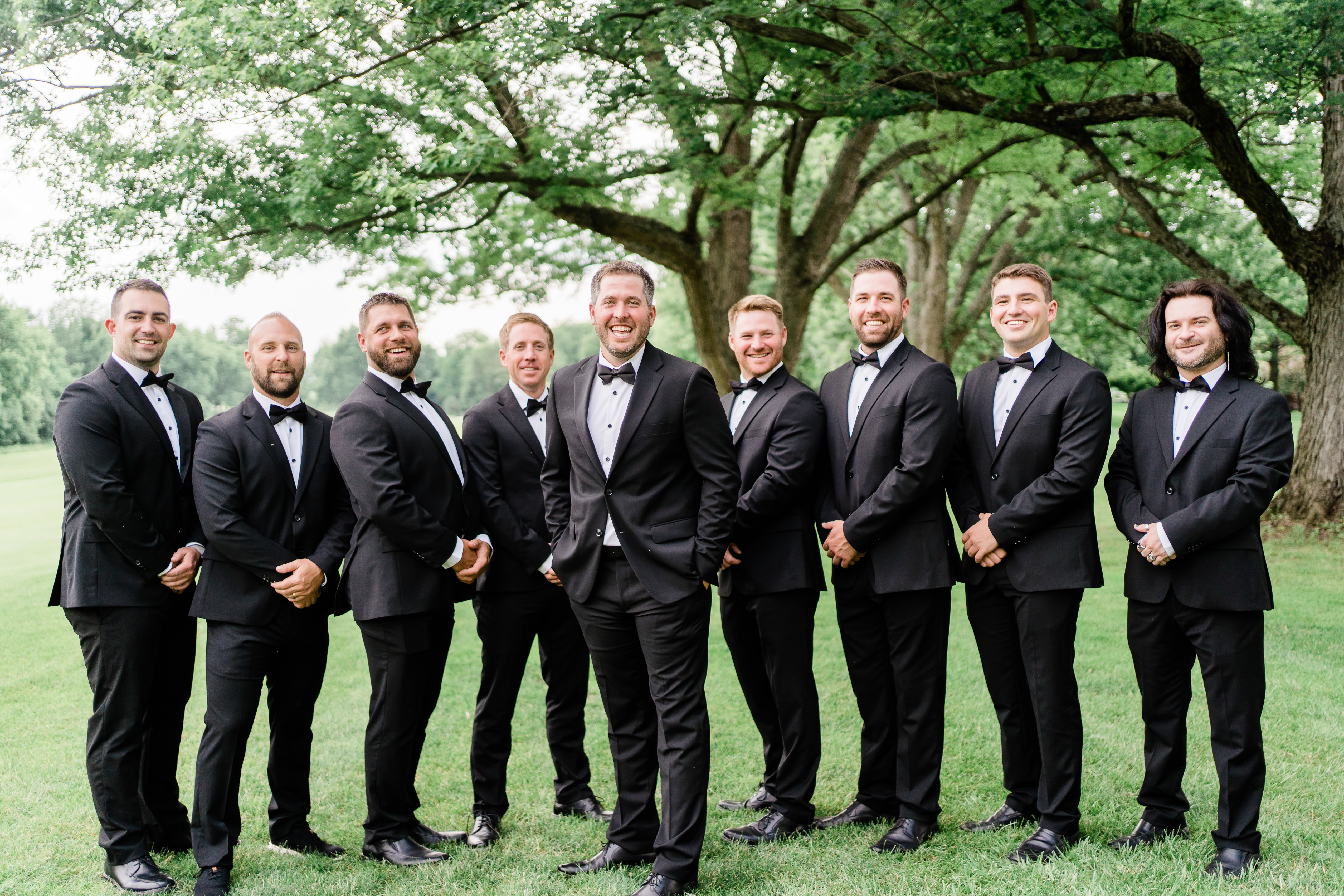 groom and groomsmen standing together wearing tuxedos