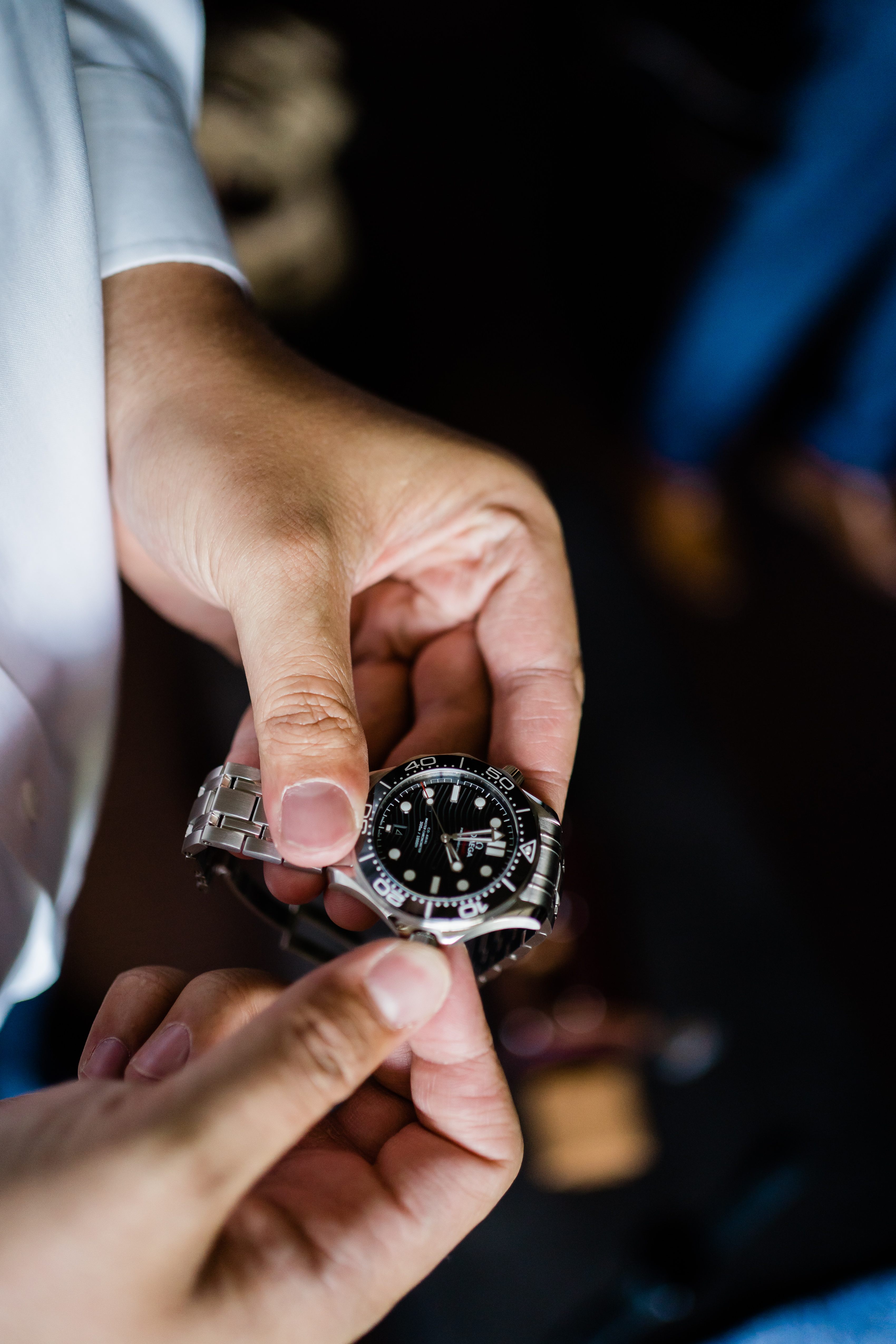 Fort Wayne wedding photographers capture groom holding watch while getting ready for stunning country club wedding