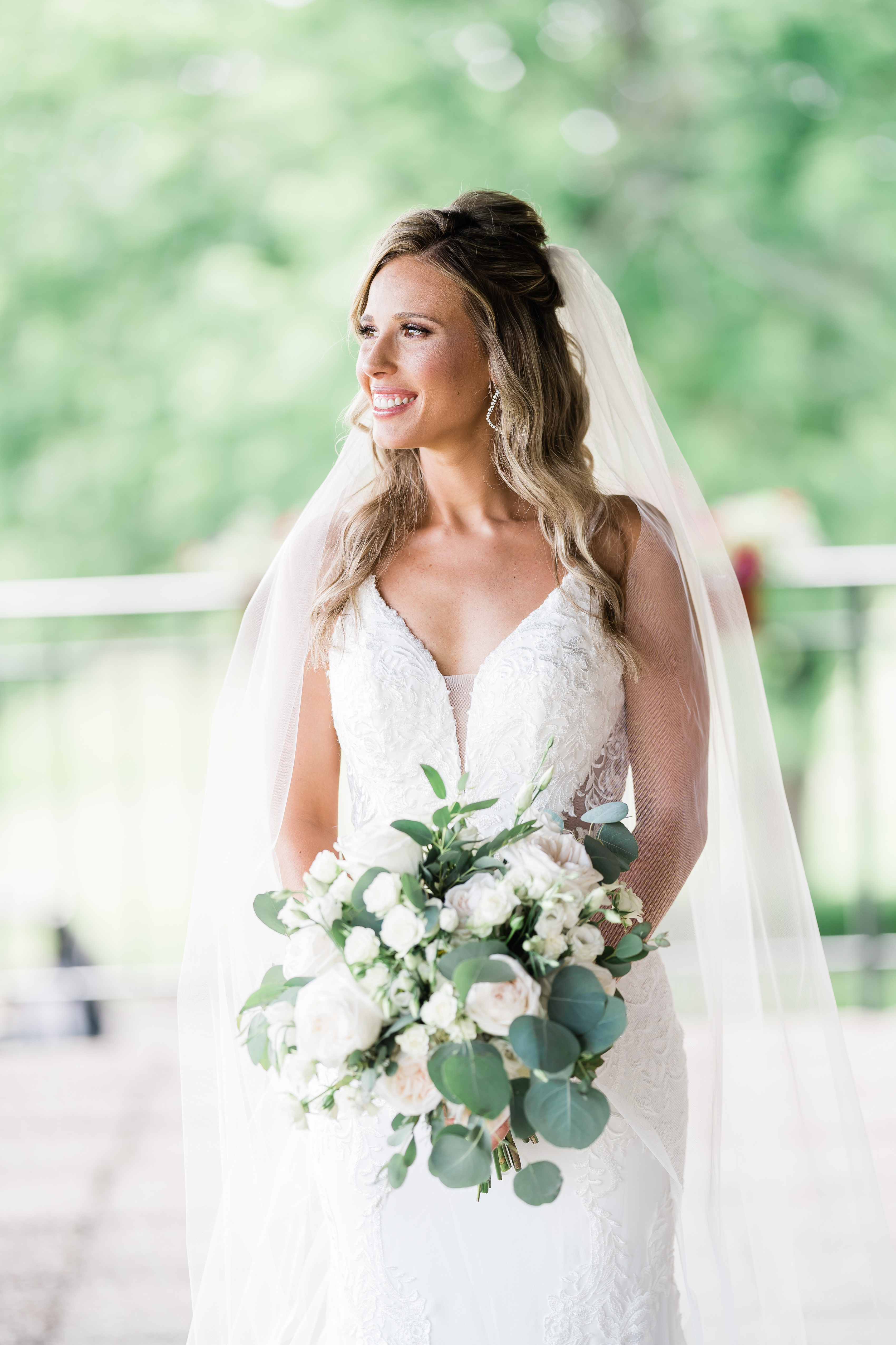 bride wearing veil standing holding bouquet