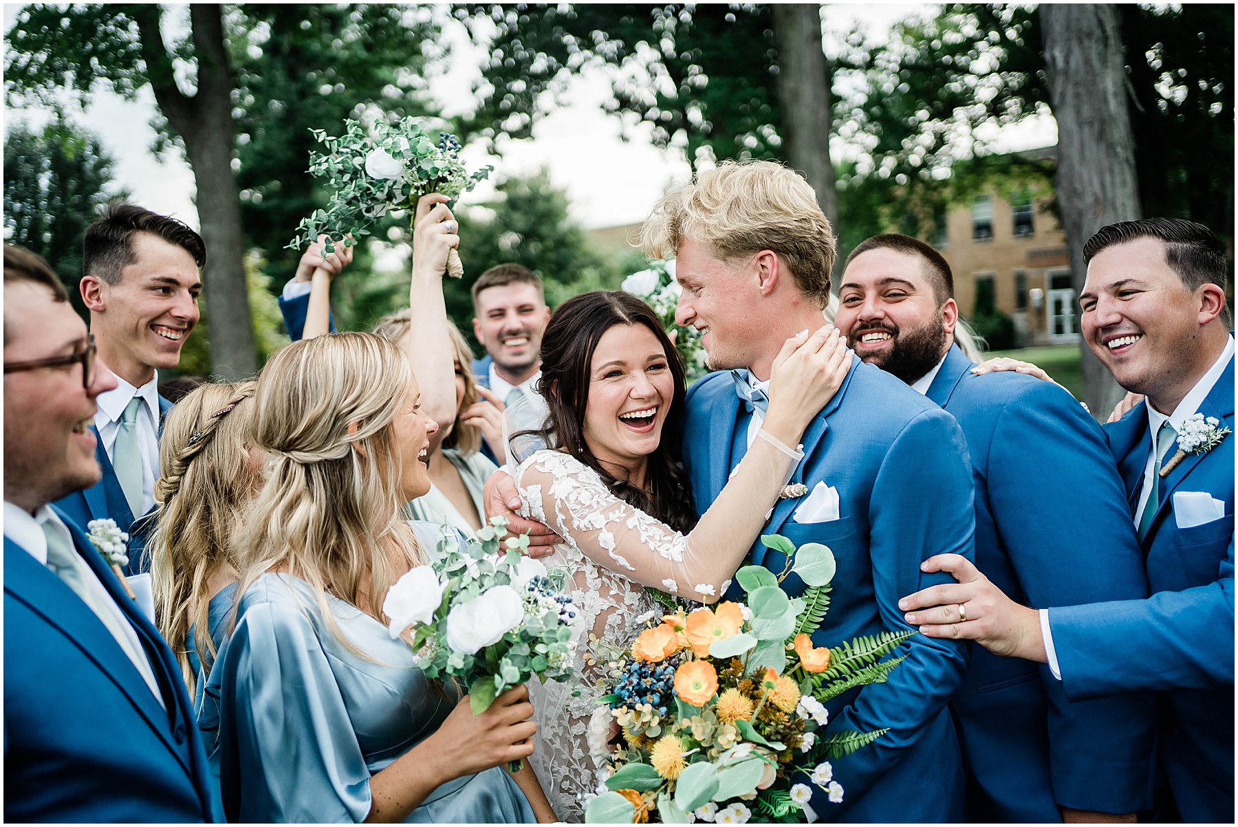 Fort Wayne wedding photographers capture bride and groom laughing together with wedding party