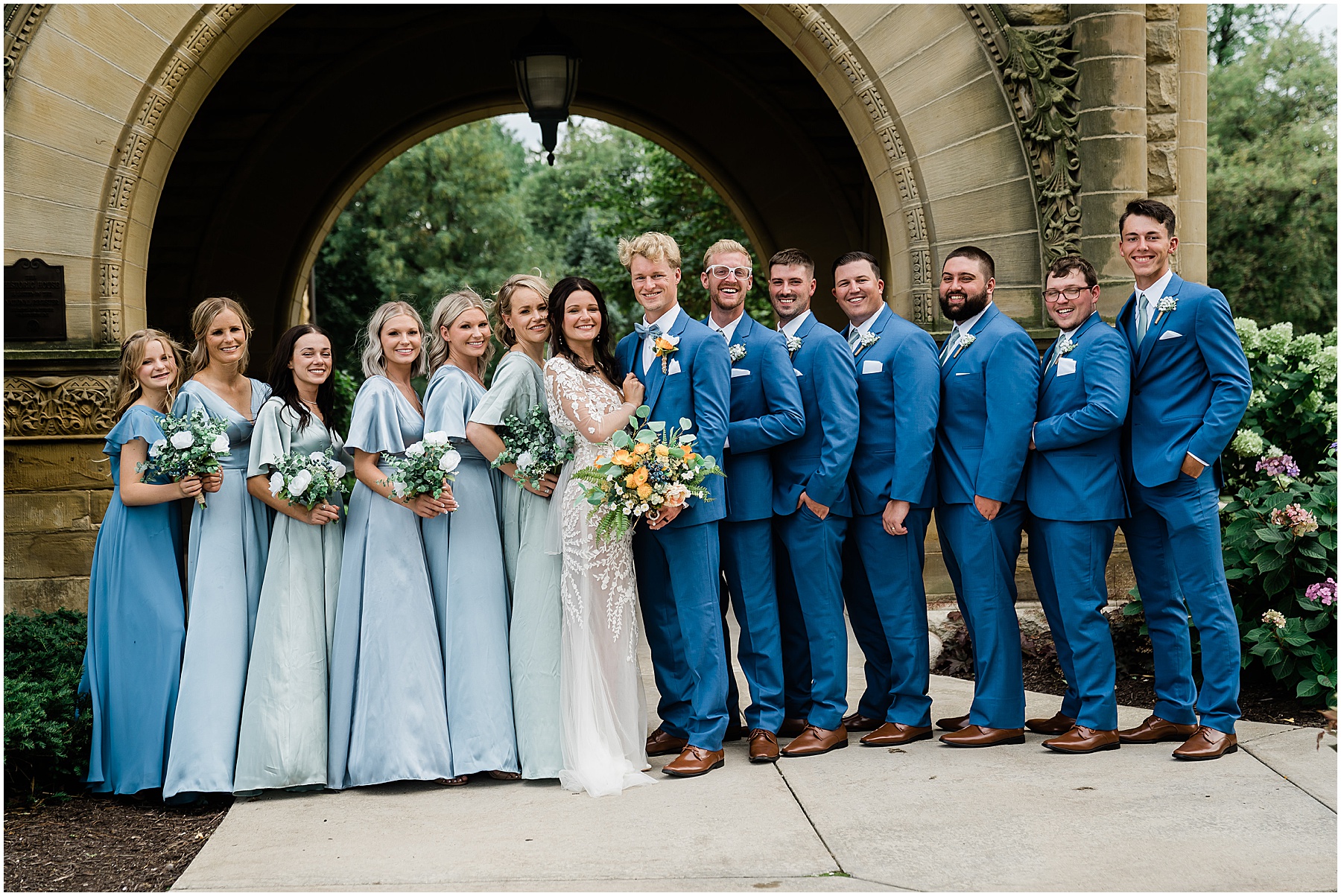 Fort Wayne wedding photographers capture bride and groom standing with wedding party 