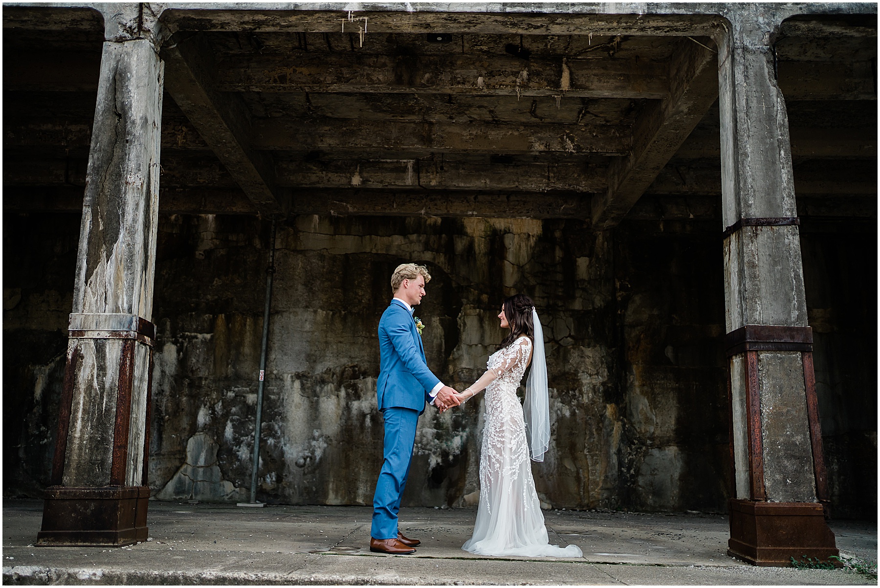 Fort Wayne wedding photographers capture bride and groom holding hands under bridge