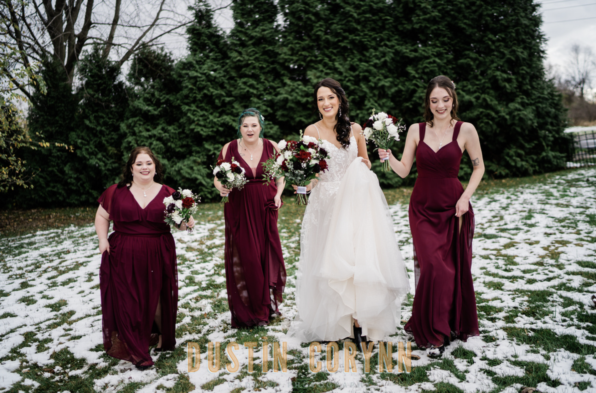 Fort Wayne wedding photographer captures bridal party walking through snow during bridal portraits