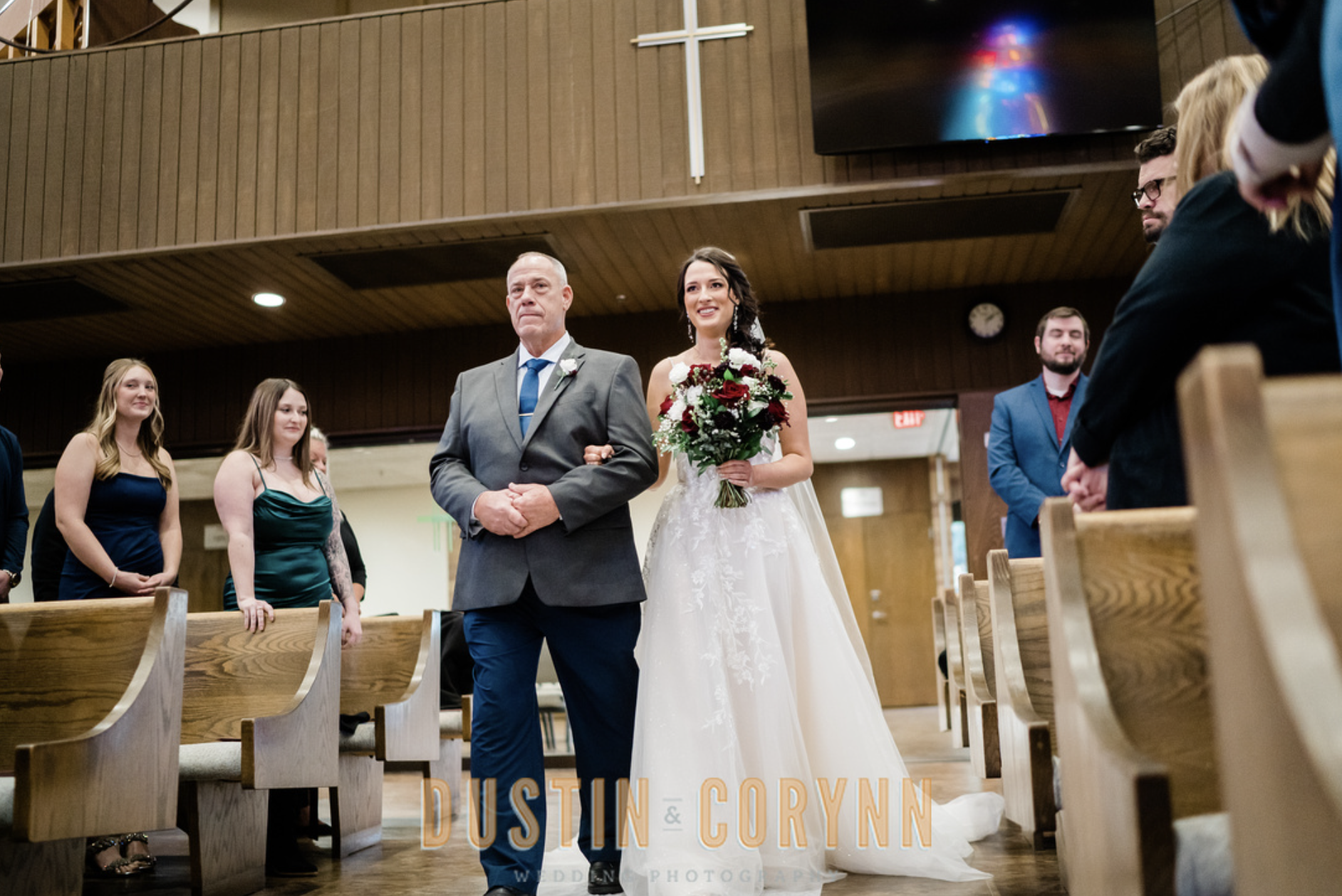bride being walked down aisle by her father while wearing wedding gown