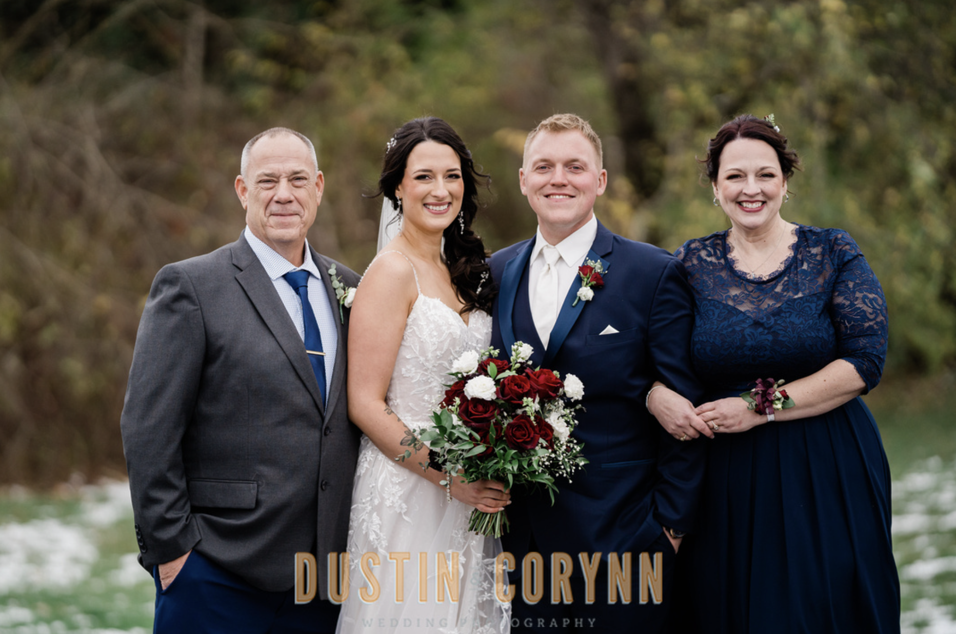 bride and groom standing with family during family portraits