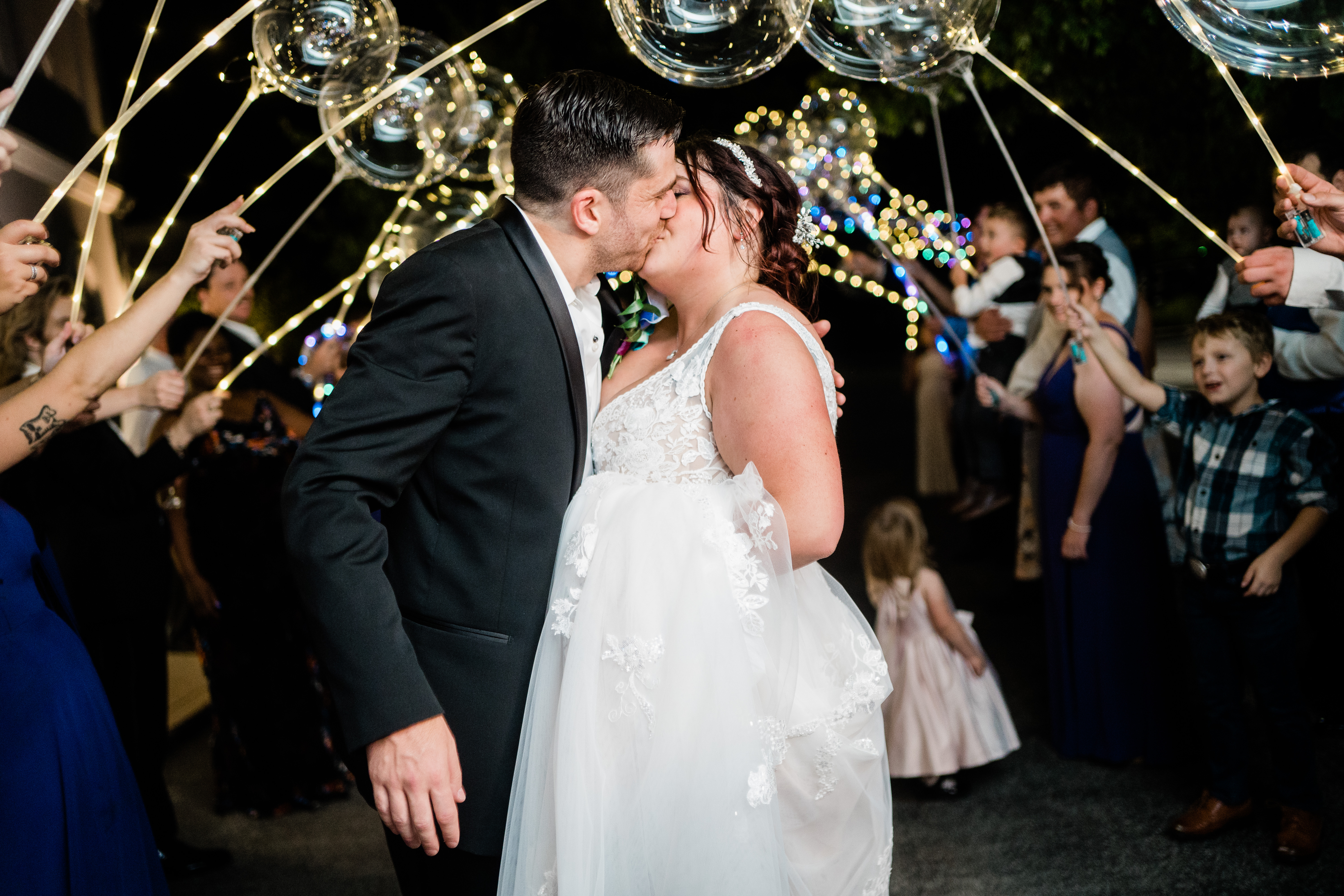 Fort Wayne wedding photographer captures  bride and groom kissing during wedding send off